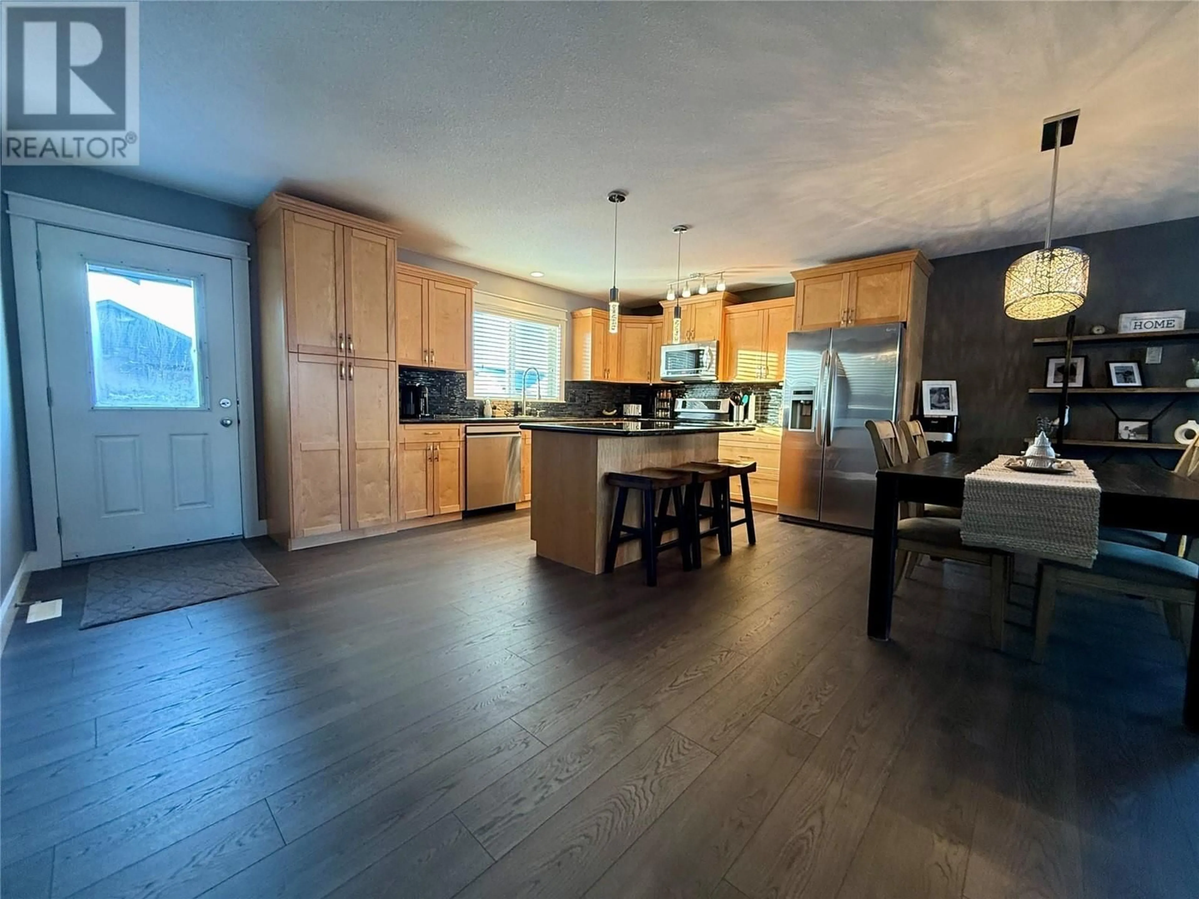 Open concept kitchen, wood/laminate floor for 1825 84 Avenue, Dawson Creek British Columbia V1G0E4