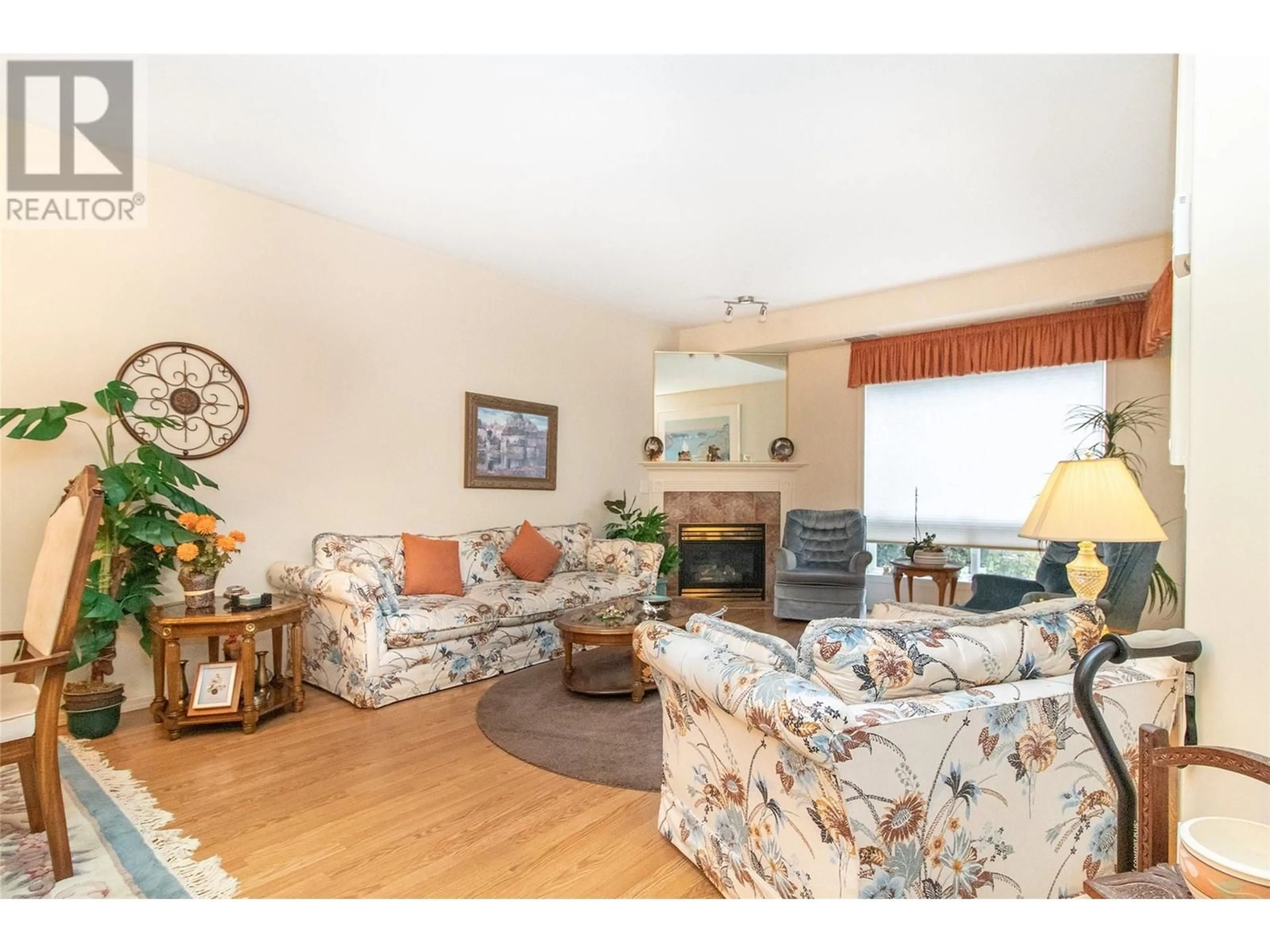 Living room with furniture, wood/laminate floor for 2300 Benvoulin Road Unit# 107, Kelowna British Columbia V1W2C6