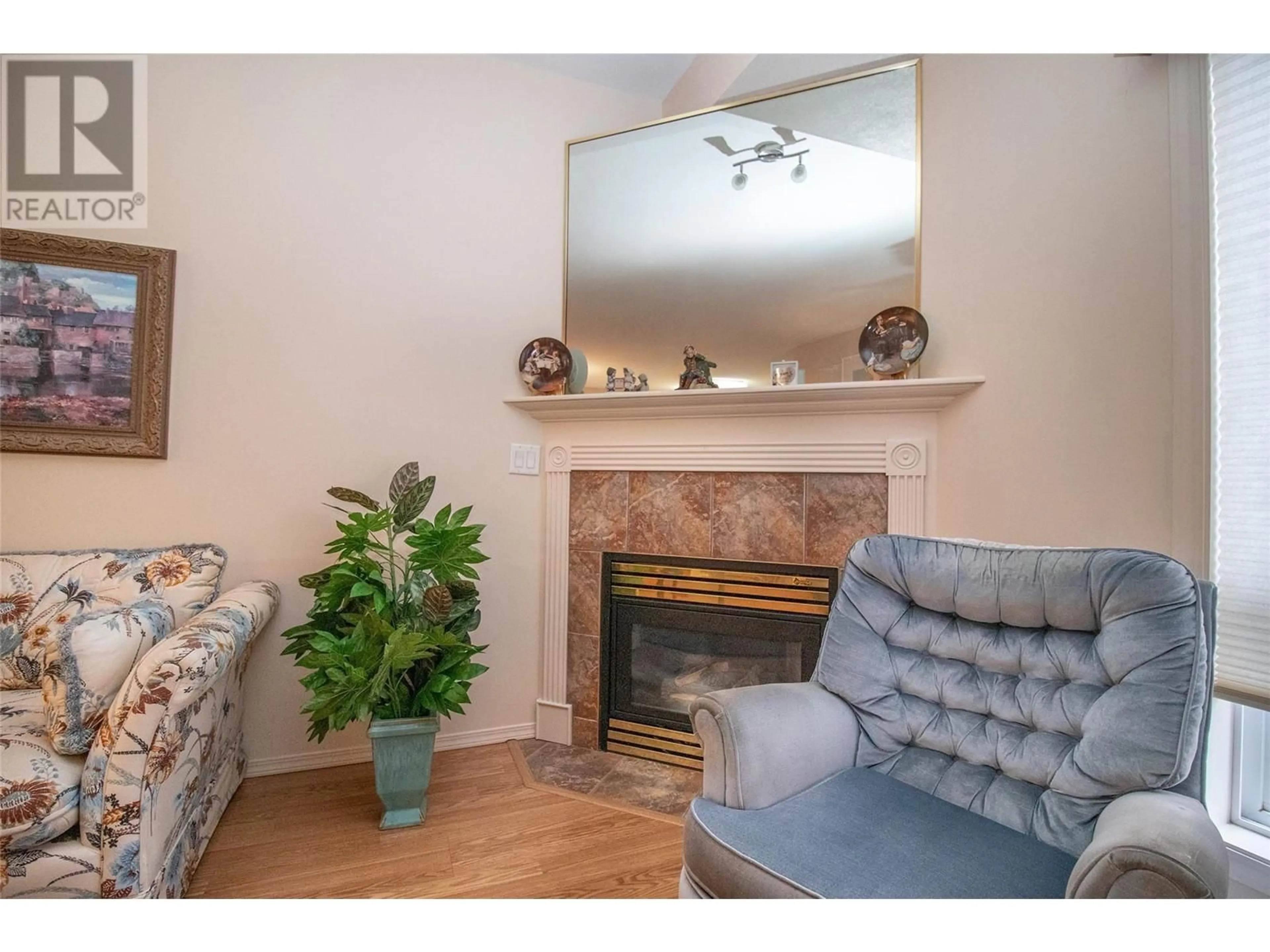 Living room with furniture, wood/laminate floor for 2300 Benvoulin Road Unit# 107, Kelowna British Columbia V1W2C6