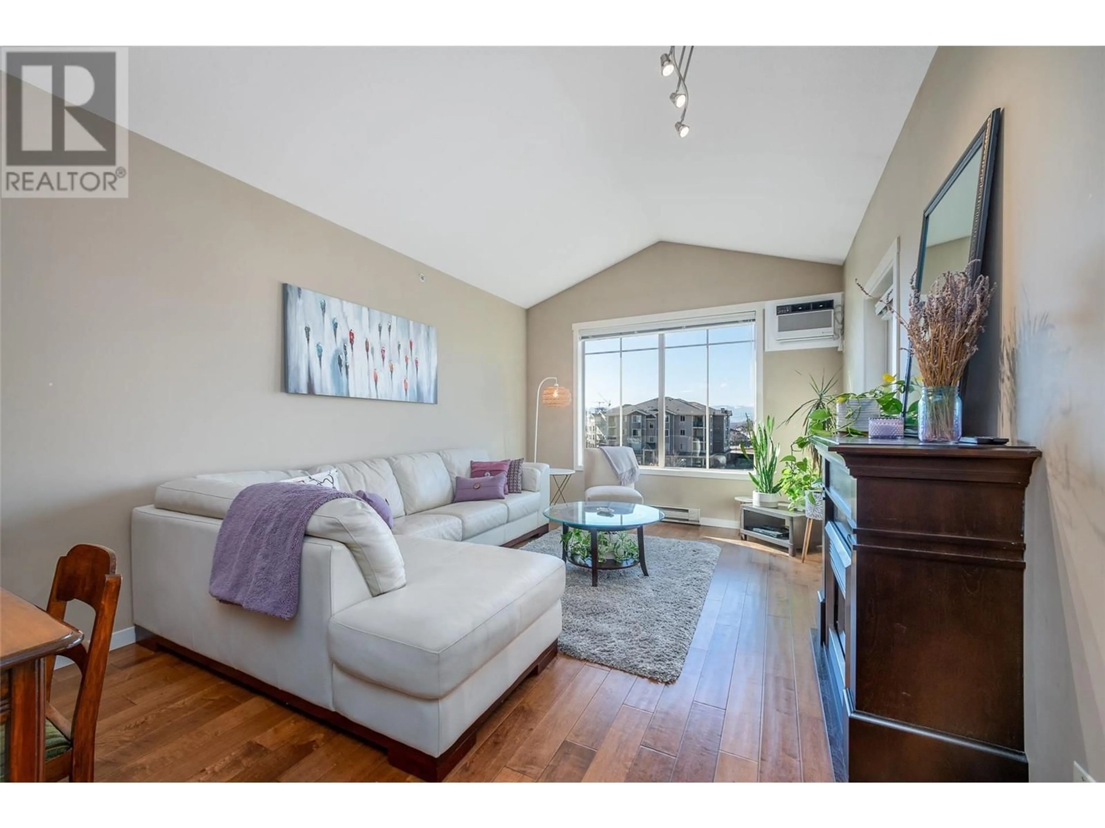 Living room with furniture, wood/laminate floor for 3735 Casorso Road Unit# 413, Kelowna British Columbia V1W5G1