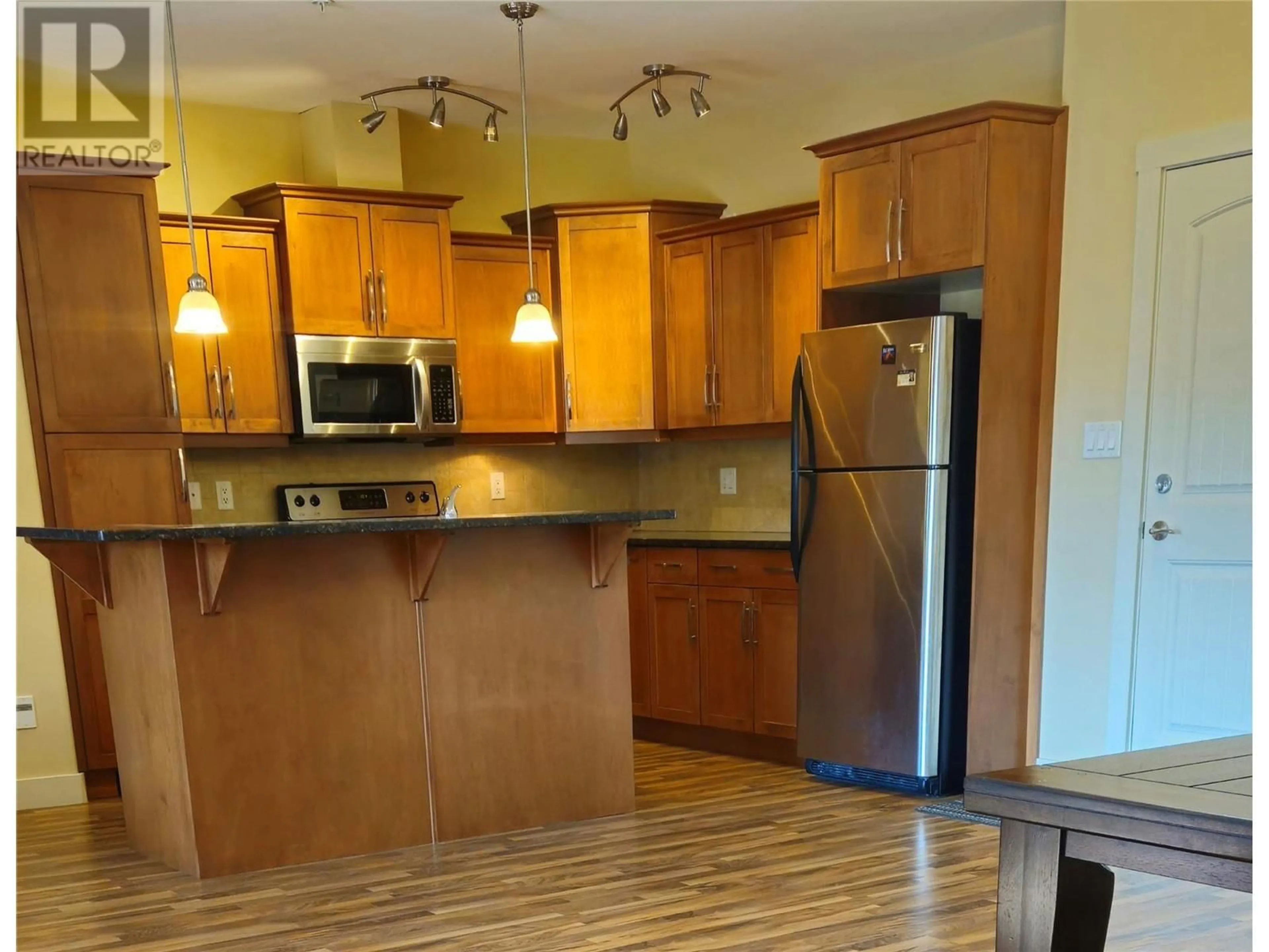 Open concept kitchen, wood/laminate floor for 13615 Victoria Road Unit# 204, Summerland British Columbia V0H1Z5