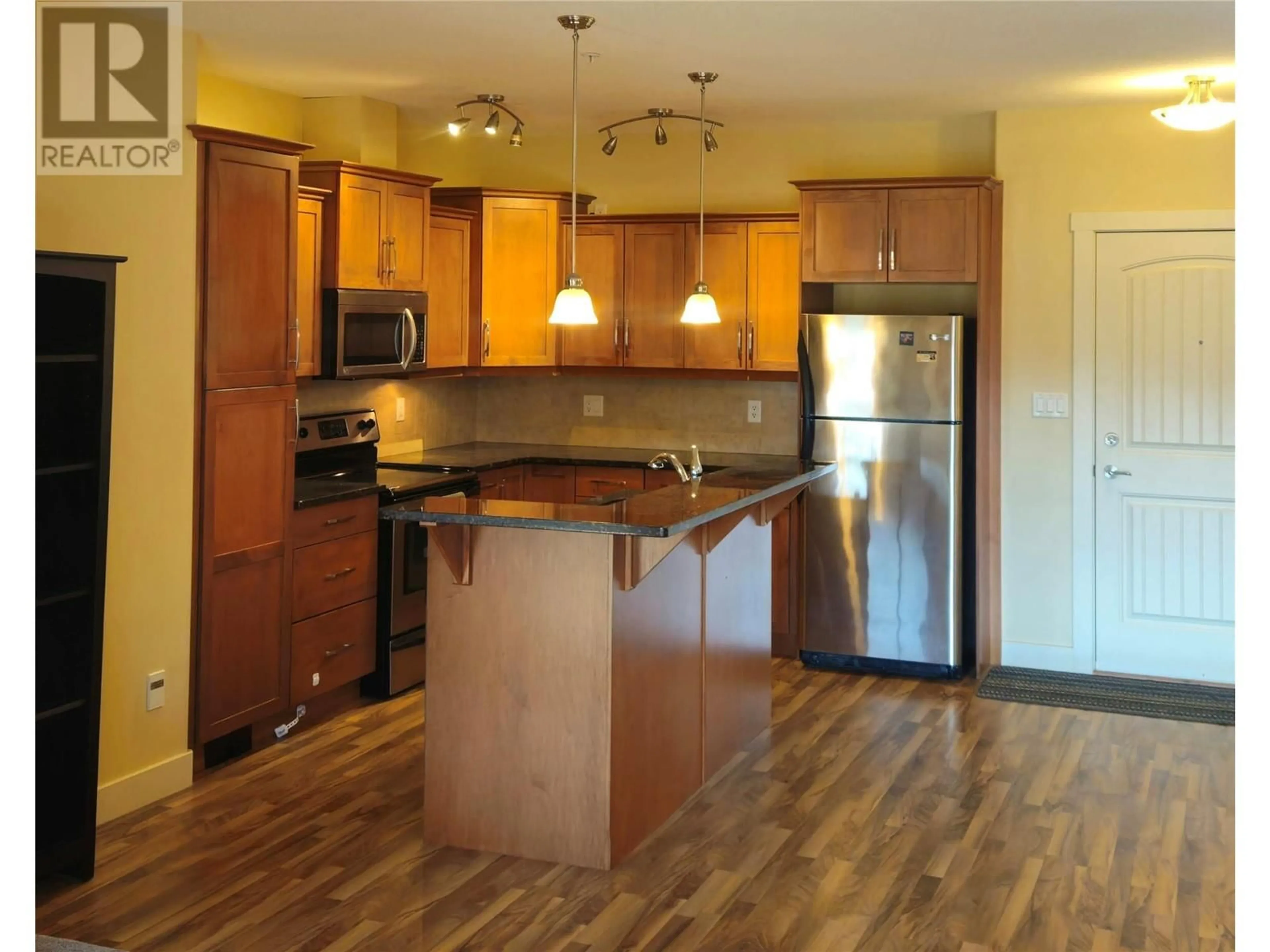 Open concept kitchen, wood/laminate floor for 13615 Victoria Road Unit# 204, Summerland British Columbia V0H1Z5