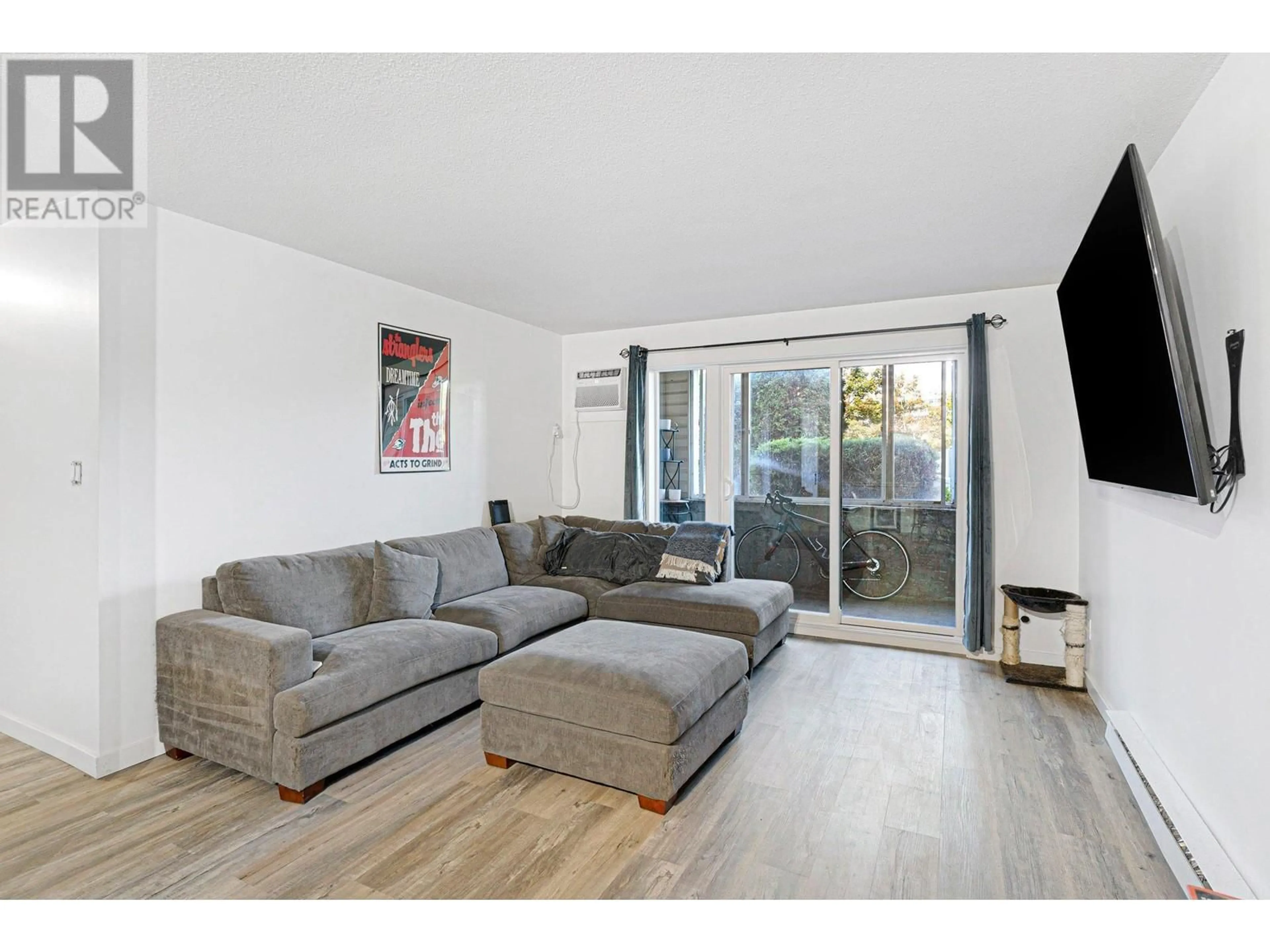 Living room with furniture, wood/laminate floor for 3163 Richter Street Unit# 117, Kelowna British Columbia V1W3R4