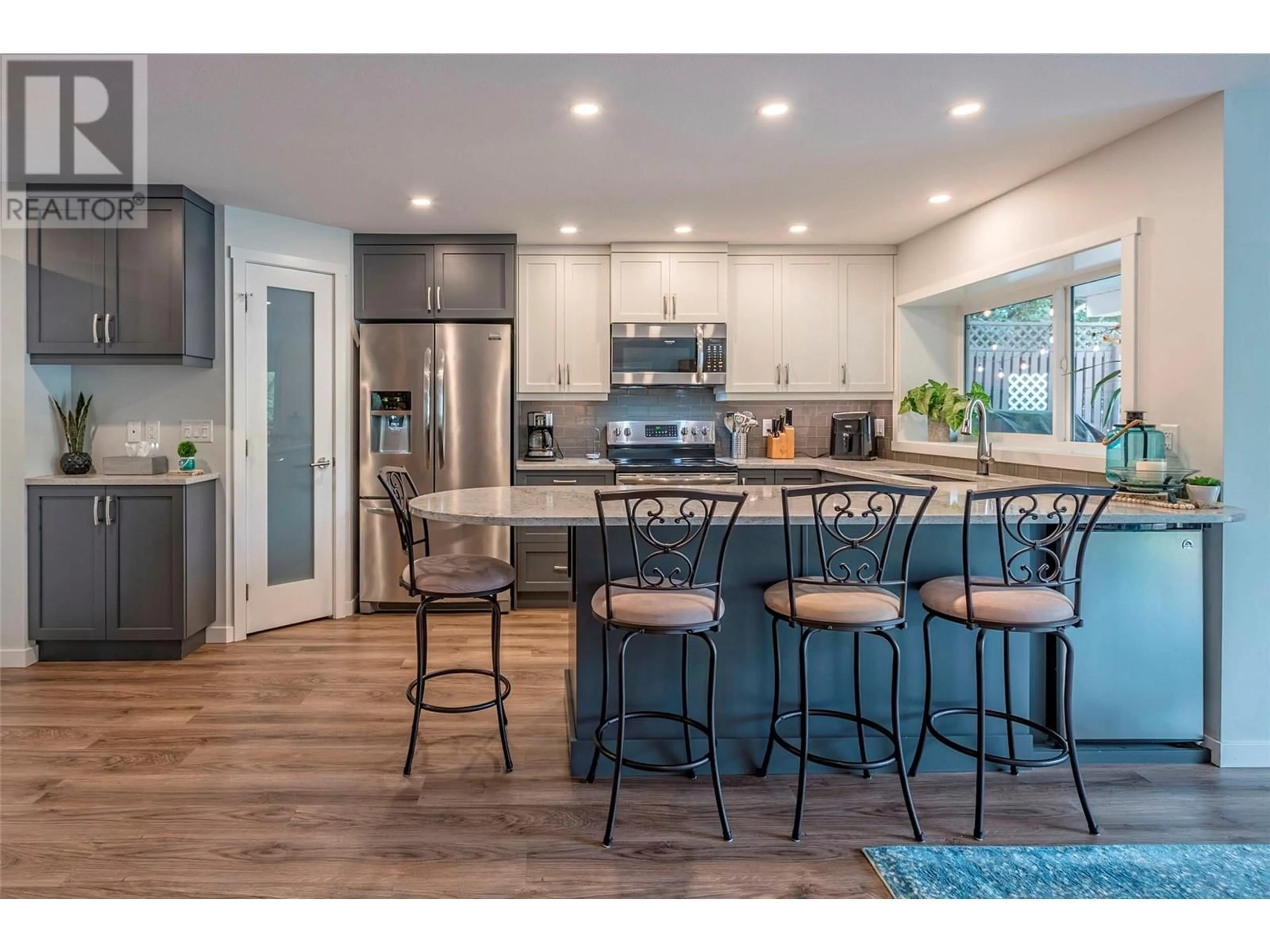 Open concept kitchen, wood/laminate floor for 7953 Okanagan Landing Road, Vernon British Columbia V1H1J4