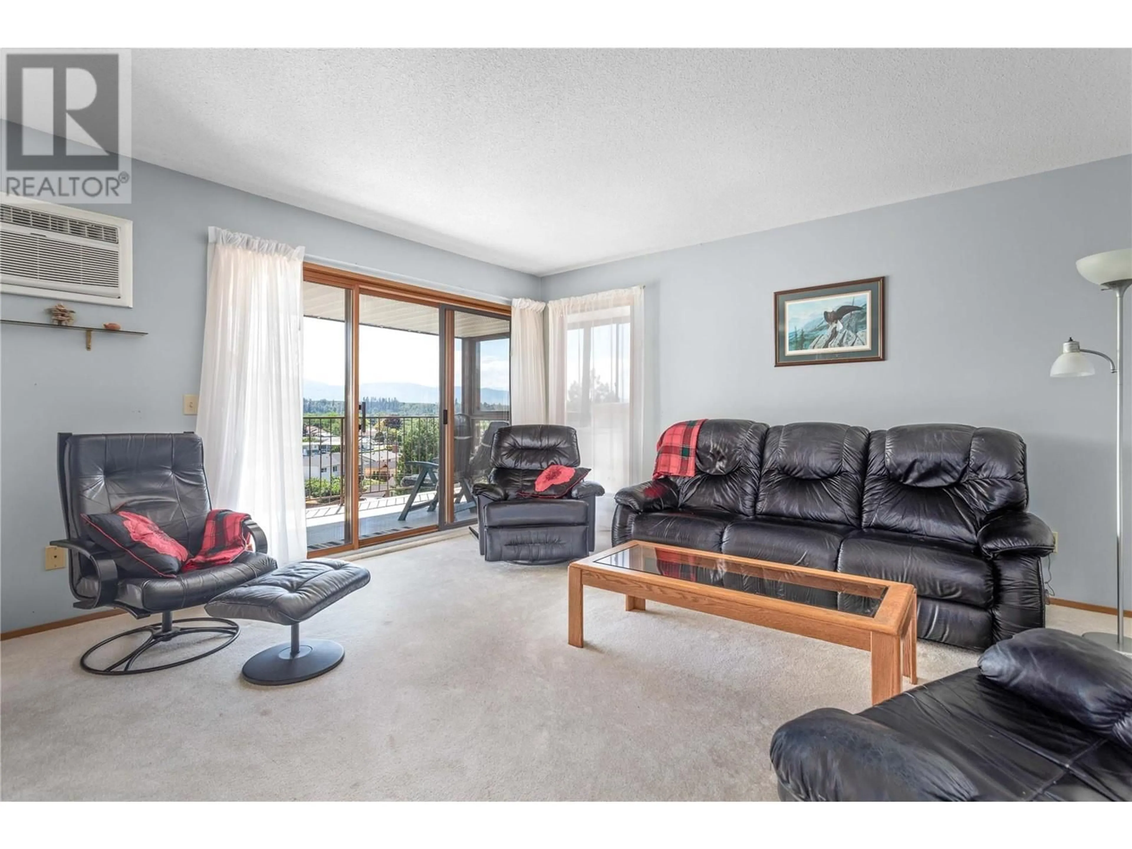 Living room with furniture, wood/laminate floor for 489 Highway 33 W Unit# 301, Kelowna British Columbia V1X1Y2