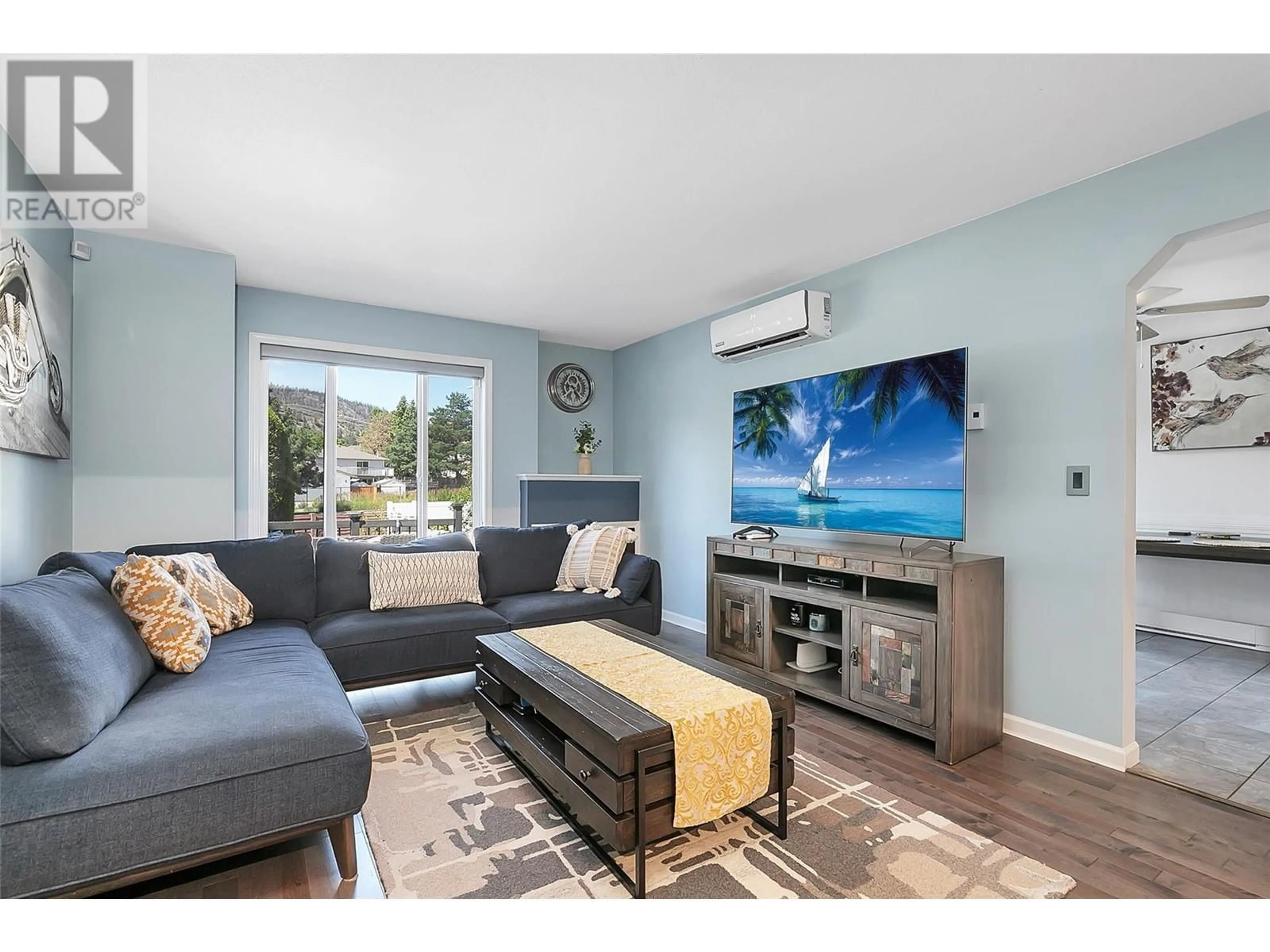 Living room with furniture, wood/laminate floor for 160 Celano Crescent Unit# 101, Kelowna British Columbia V1V1X9