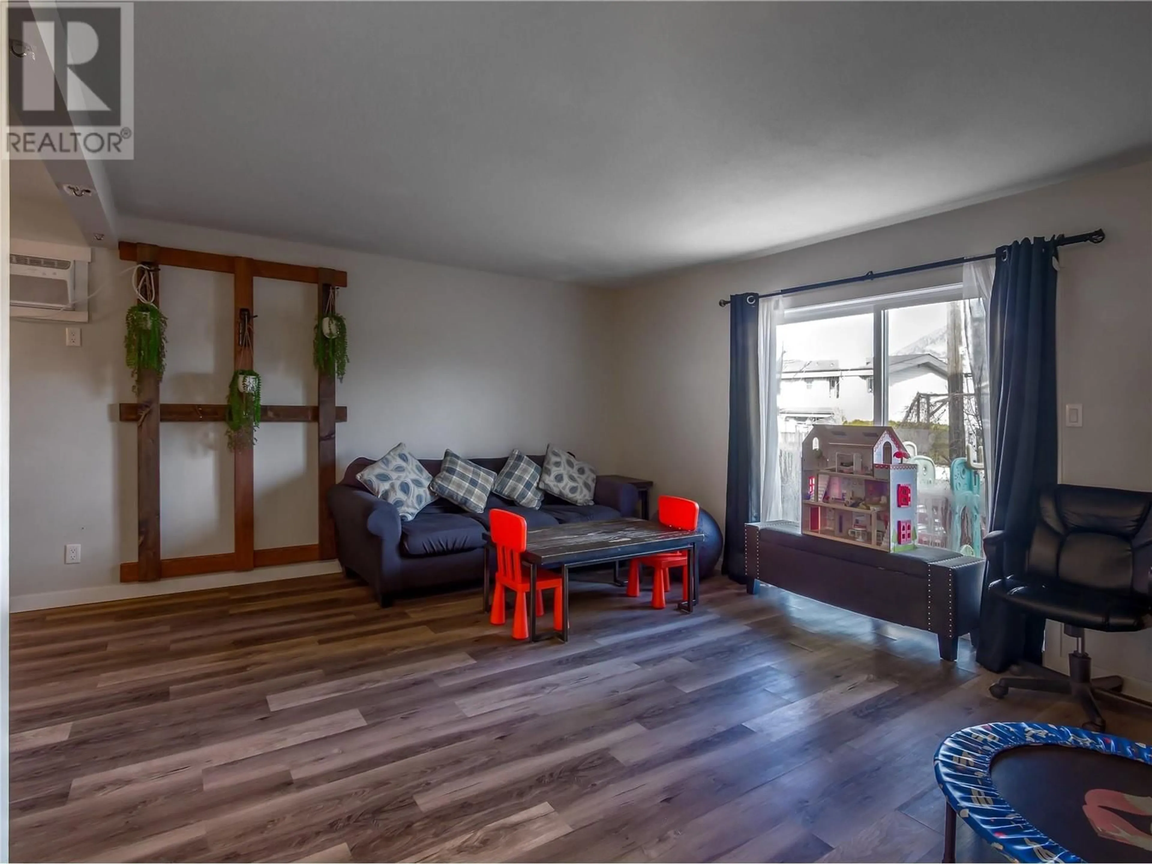 Living room with furniture, wood/laminate floor for 101 - 542 WADE AVENUE, Penticton British Columbia V2A1V5