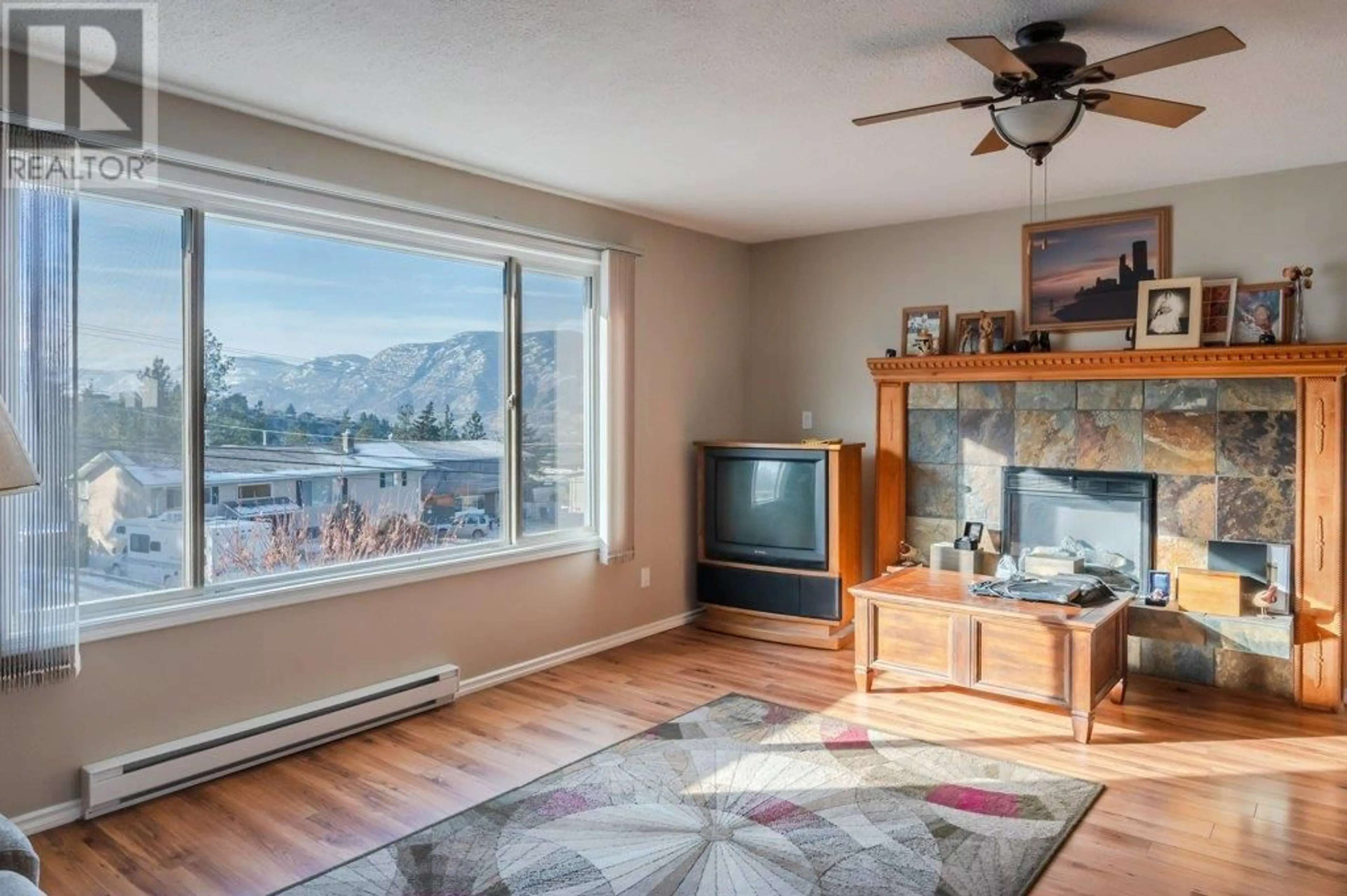 Living room with furniture, wood/laminate floor for 1555 CARMI AVENUE, Penticton British Columbia V2A8V5