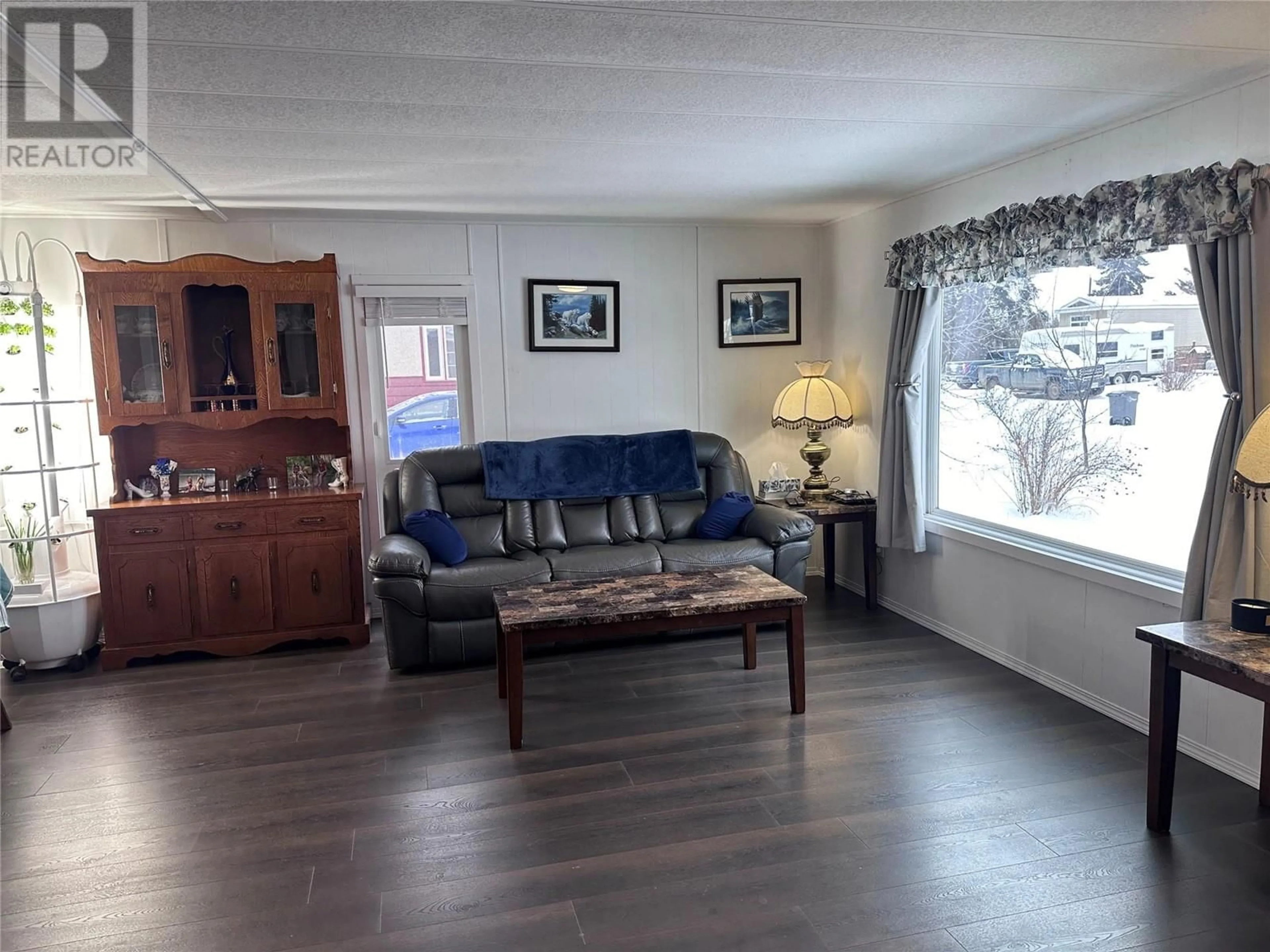 Living room with furniture, wood/laminate floor for 907 121 Avenue, Dawson Creek British Columbia V1G3K3