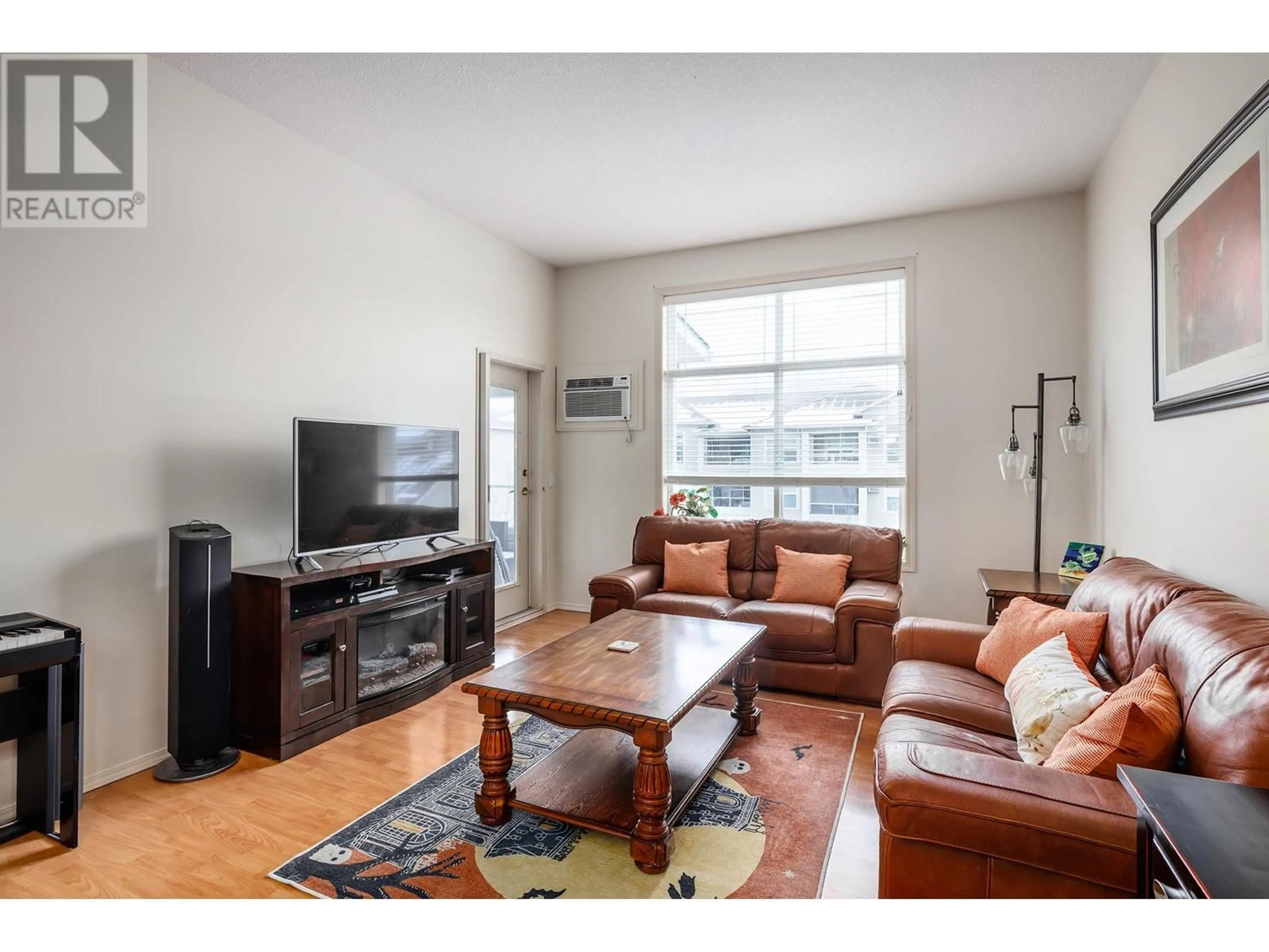 Living room with furniture, wood/laminate floor for 301 - 555 HOUGHTON ROAD, Kelowna British Columbia V1X7P9
