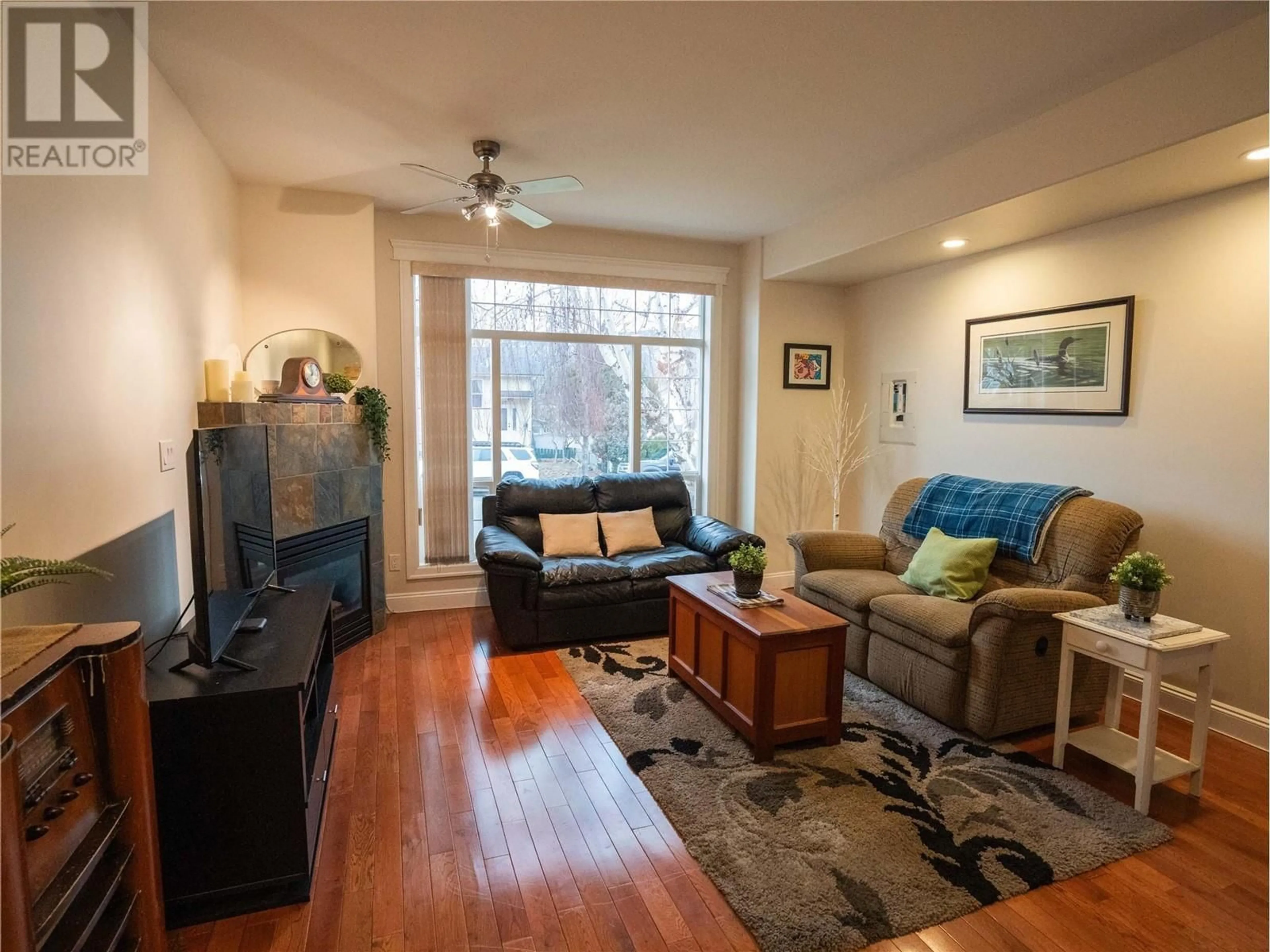 Living room with furniture, wood/laminate floor for 586 Papineau Street Unit# 102, Penticton British Columbia V2A4X5