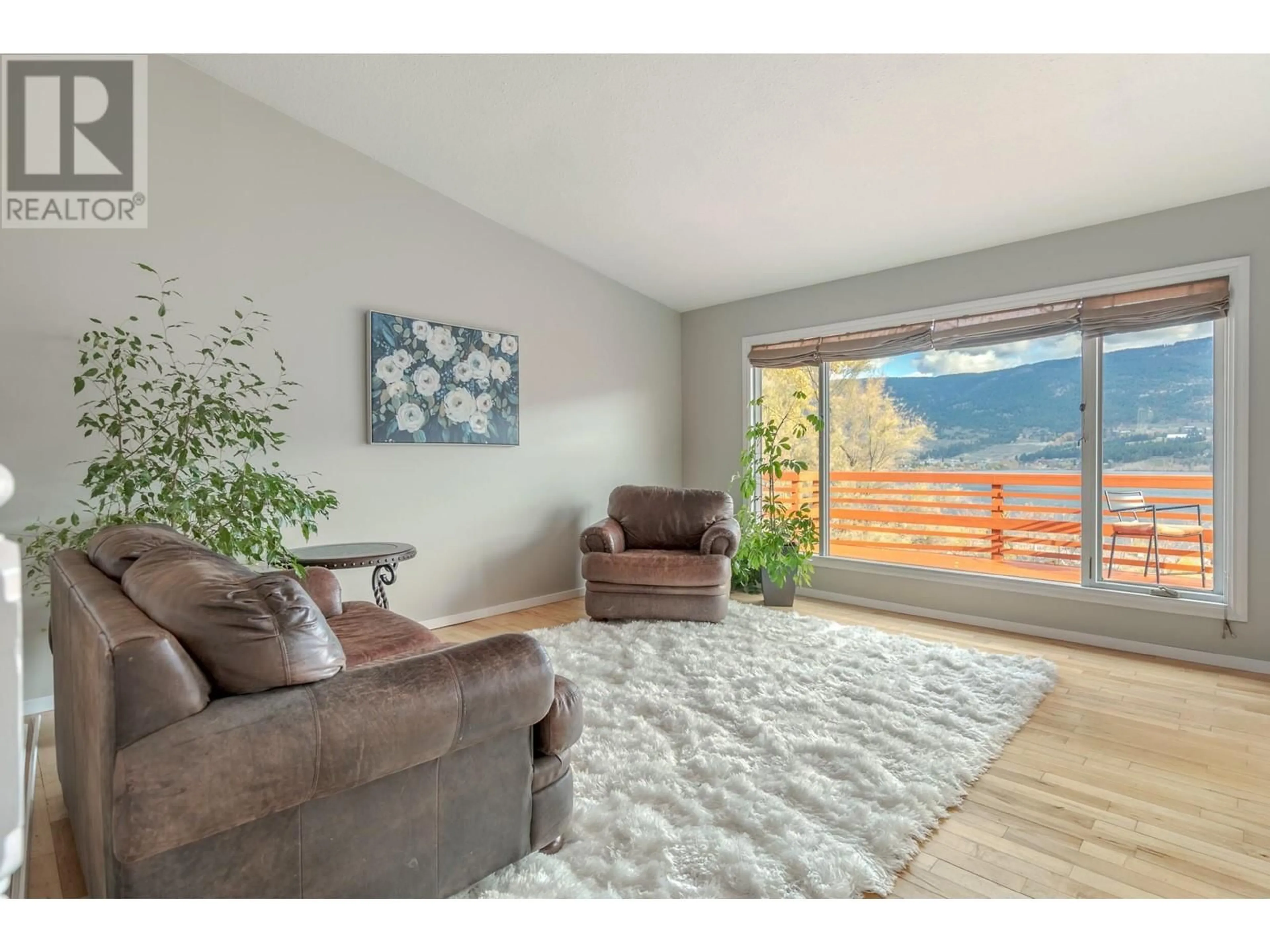 Living room with furniture, wood/laminate floor for 15069 Old Mission Road, Lake Country British Columbia V4V2A9