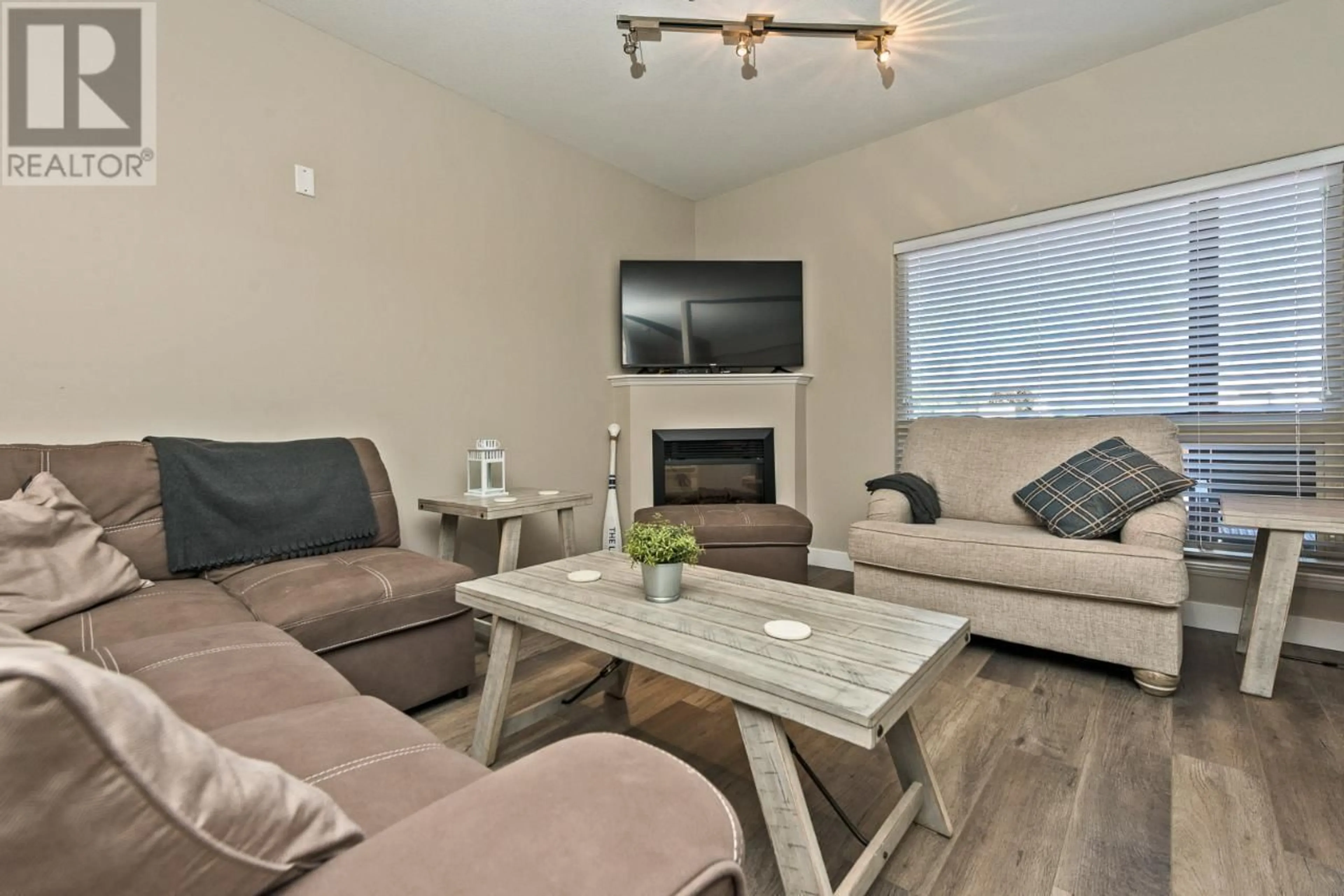 Living room with furniture, wood/laminate floor for 103 - 4300 44TH AVENUE, Osoyoos British Columbia V0H1V6