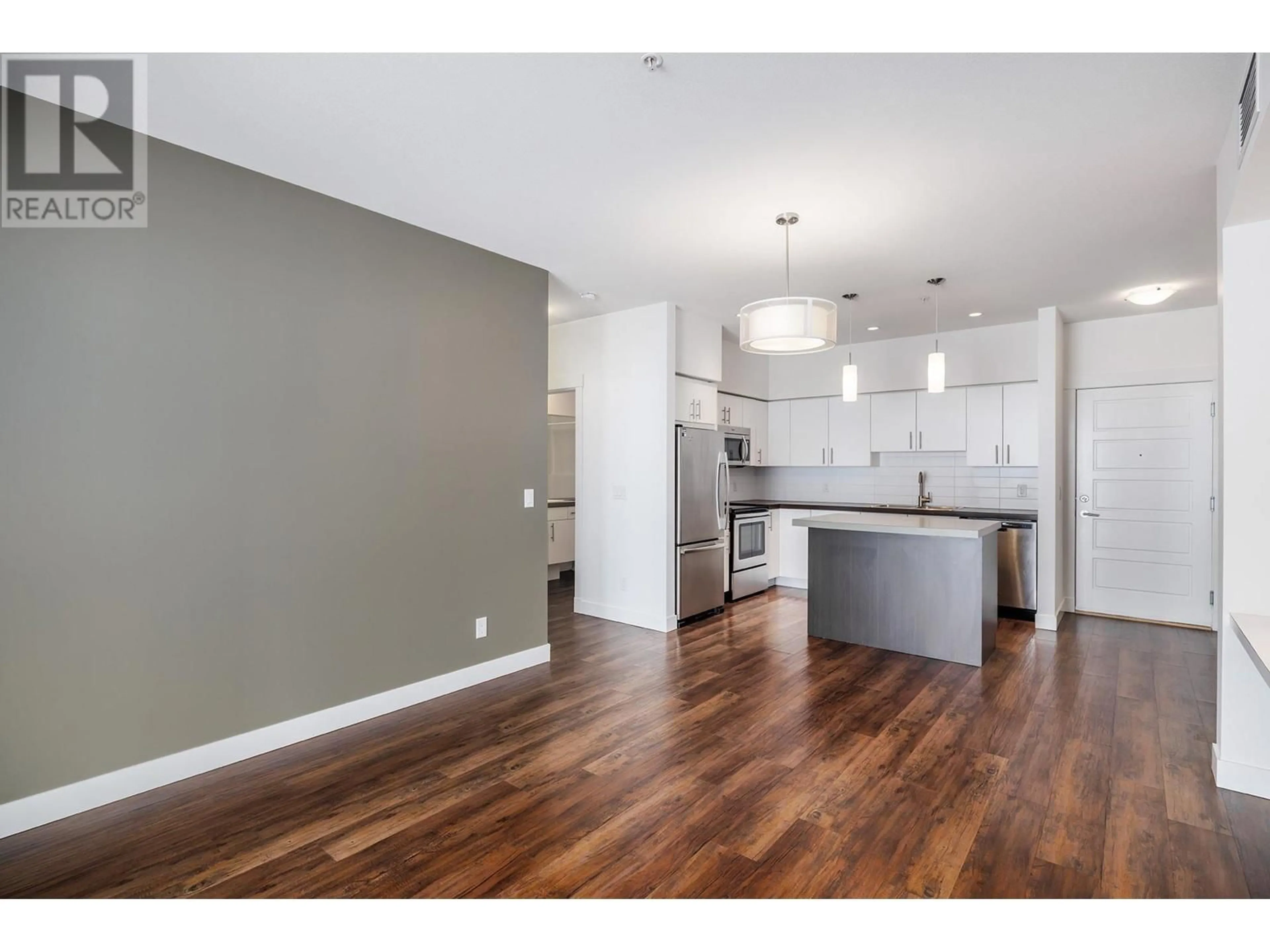 Open concept kitchen, wood/laminate floor for 975 Academy Way Unit# 313, Kelowna British Columbia V1V3C8