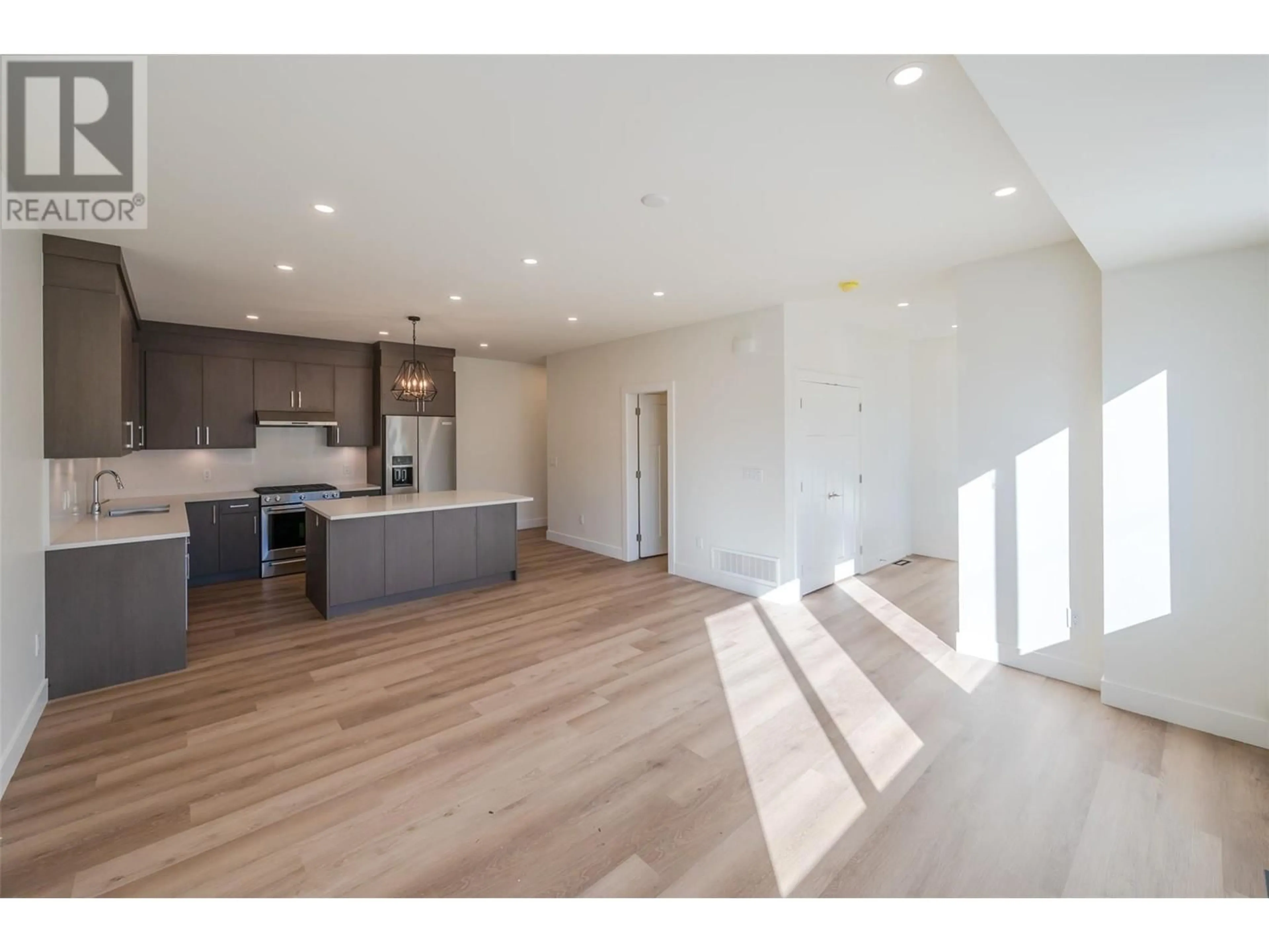 Open concept kitchen, wood/laminate floor for 1715 Fairford Drive Unit# 101, Penticton British Columbia V2A6C7