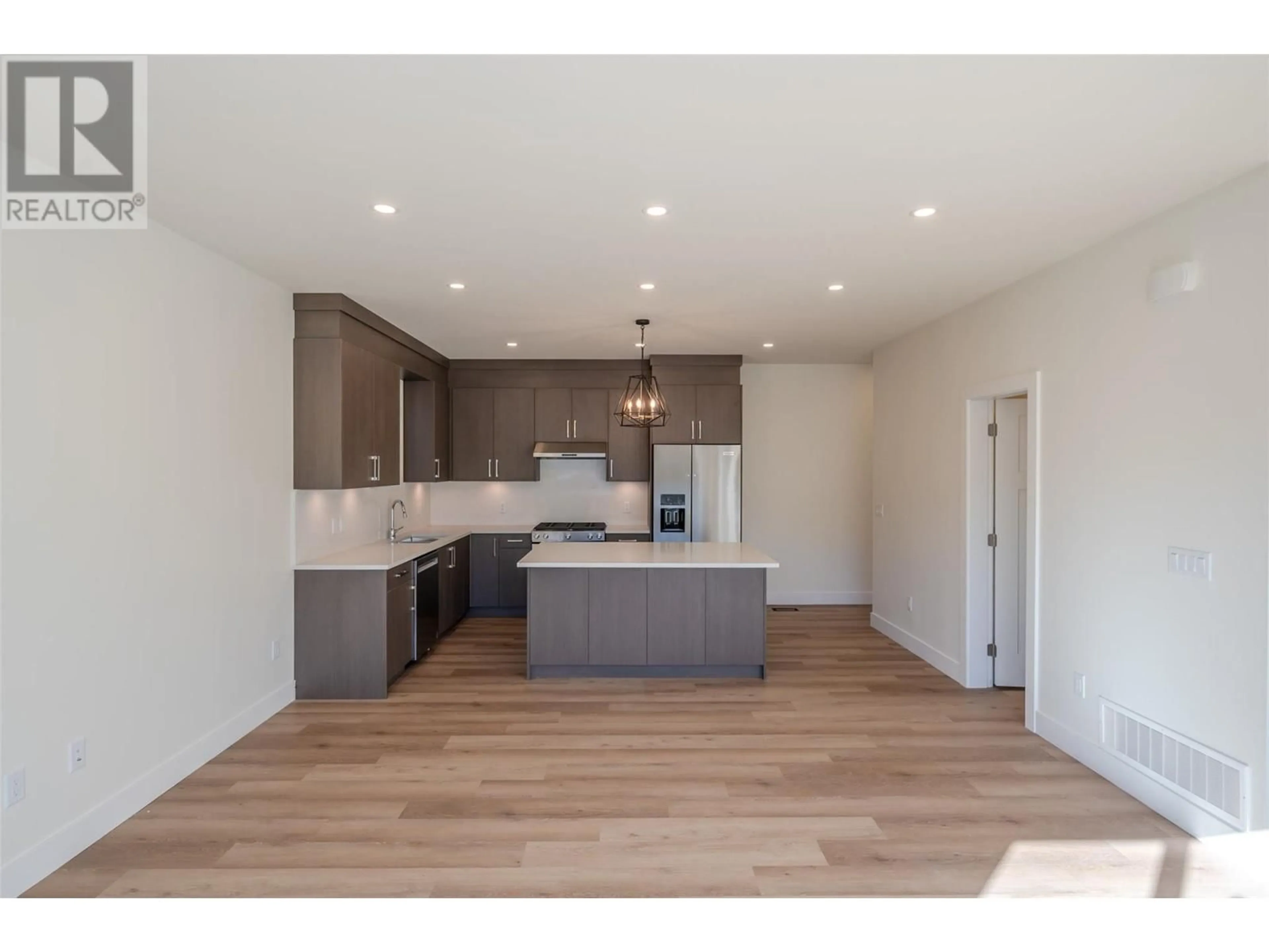 Open concept kitchen, wood/laminate floor for 1715 Fairford Drive Unit# 101, Penticton British Columbia V2A6C7