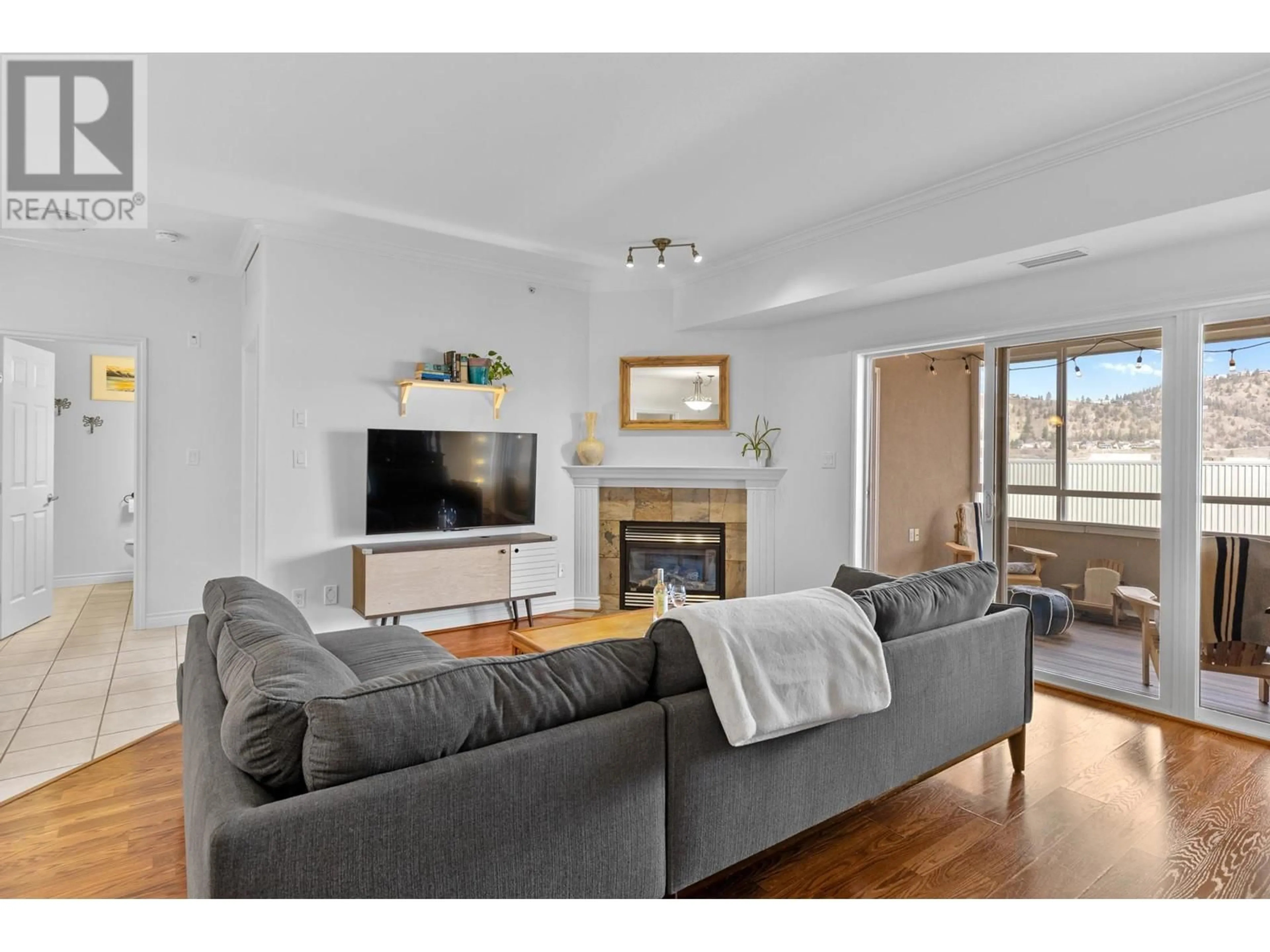 Living room with furniture, wood/laminate floor for 1961 Durnin Road Unit# 403, Kelowna British Columbia V1X7Z6