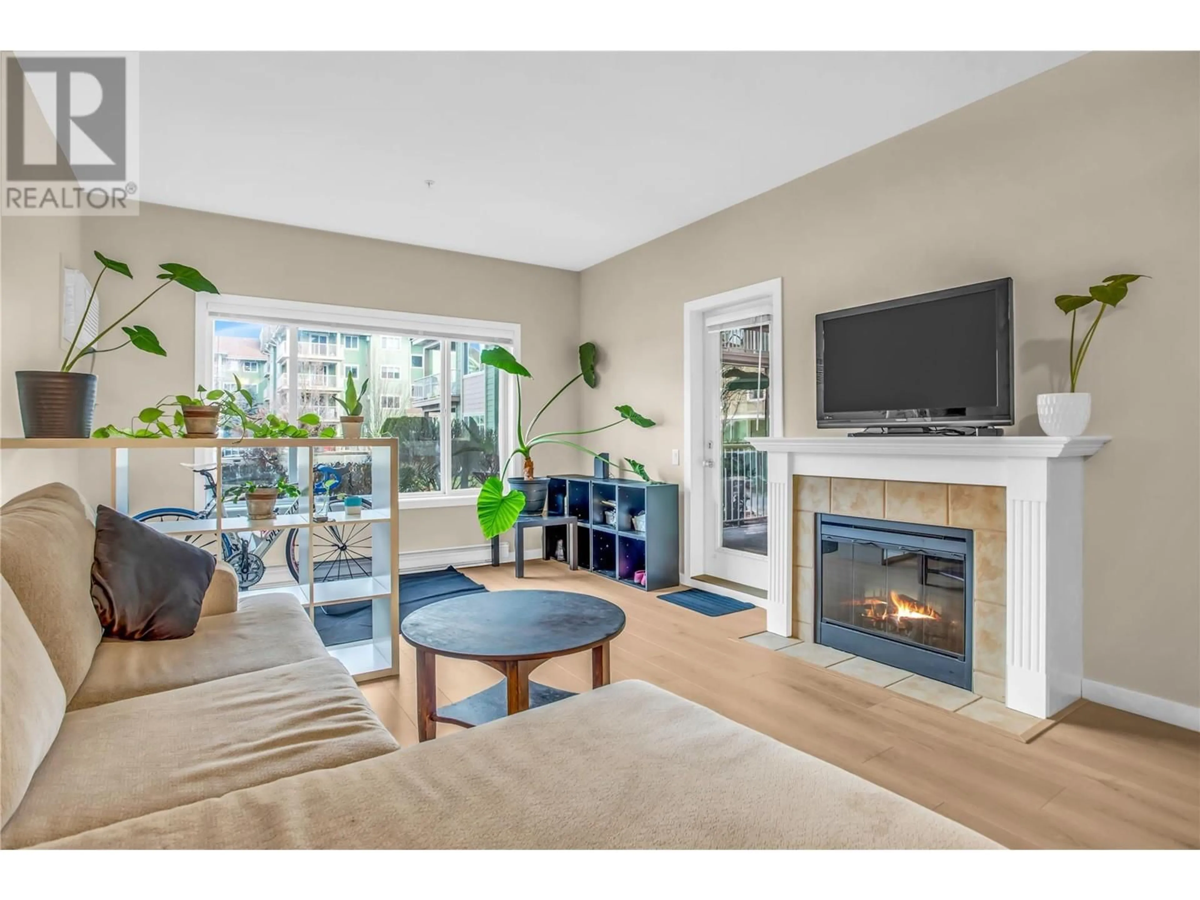 Living room with furniture, wood/laminate floor for 680 Lequime Road Unit# 101, Kelowna British Columbia V1W1A4