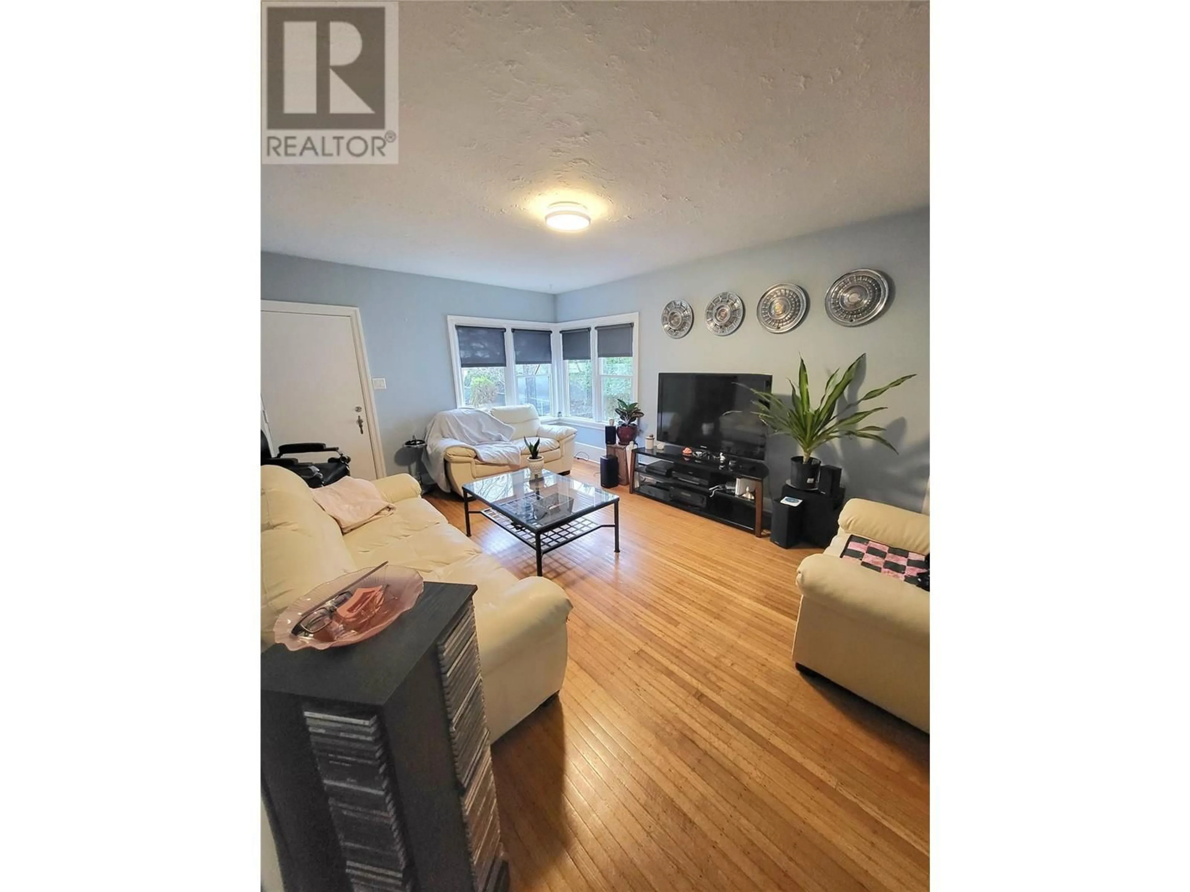 Living room with furniture, wood/laminate floor for 857 Main Street, Penticton British Columbia V2A5E3