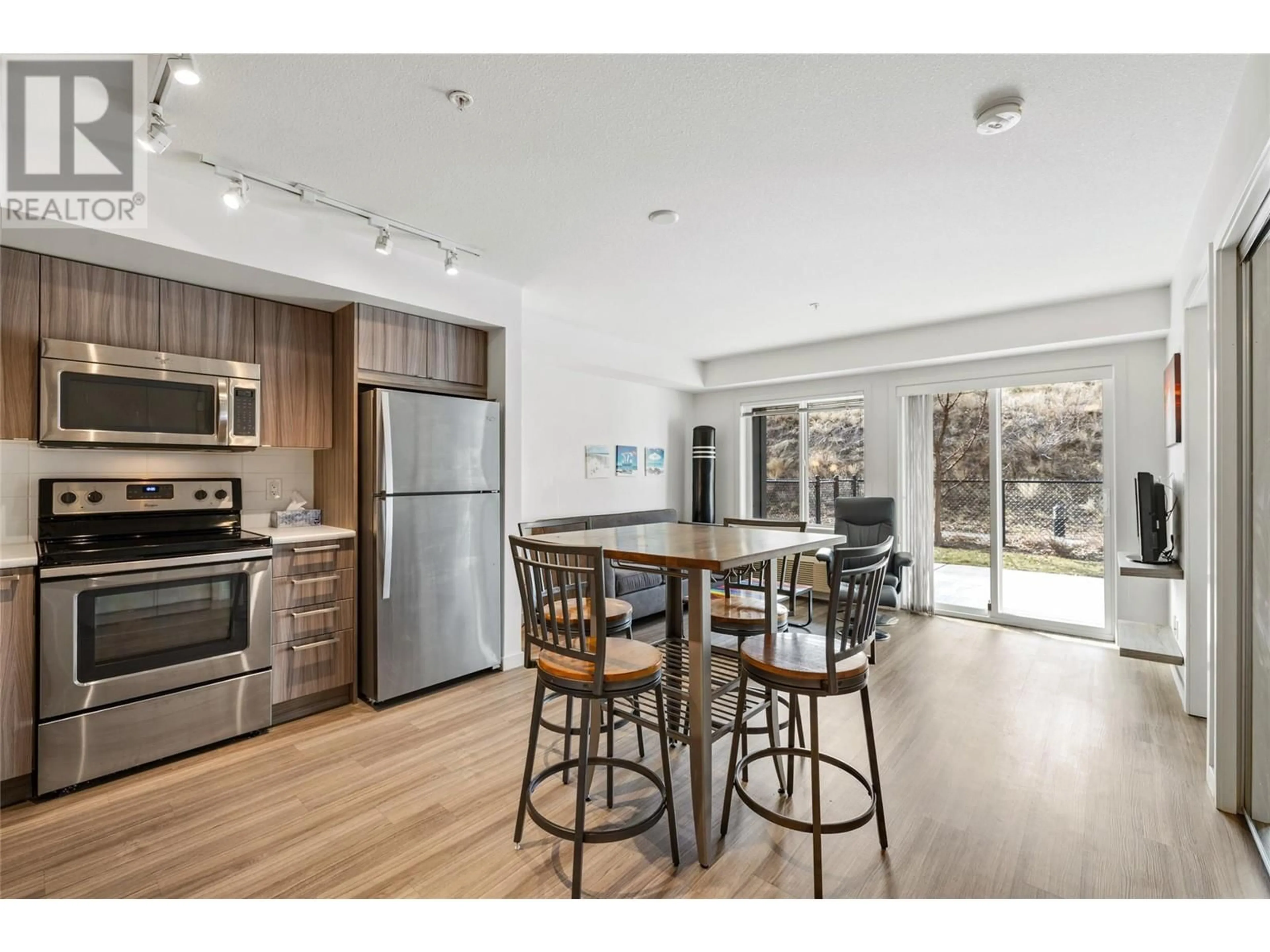 Open concept kitchen, wood/laminate floor for 111 - 883 ACADEMY WAY, Kelowna British Columbia V1V0A3