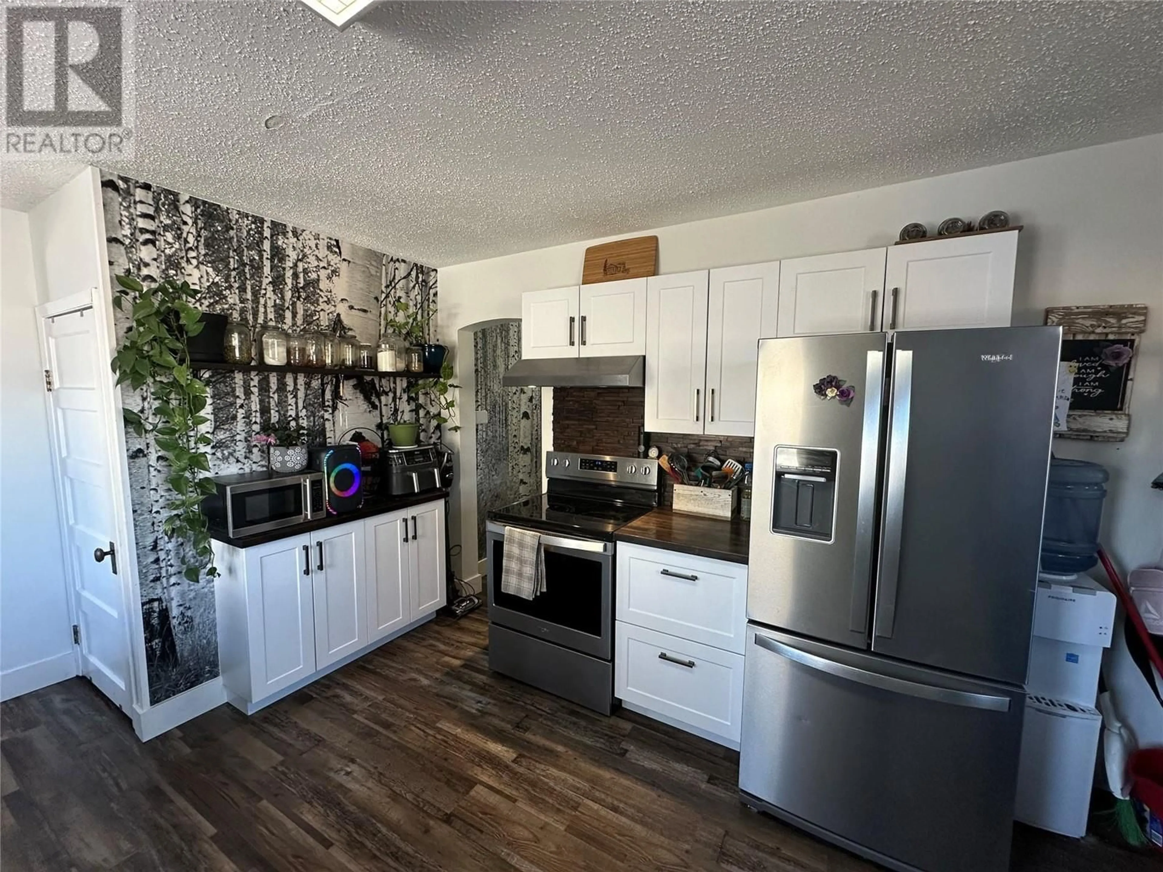 Open concept kitchen, wood/laminate floor for 1310 104 Avenue, Dawson Creek British Columbia V1G2J6