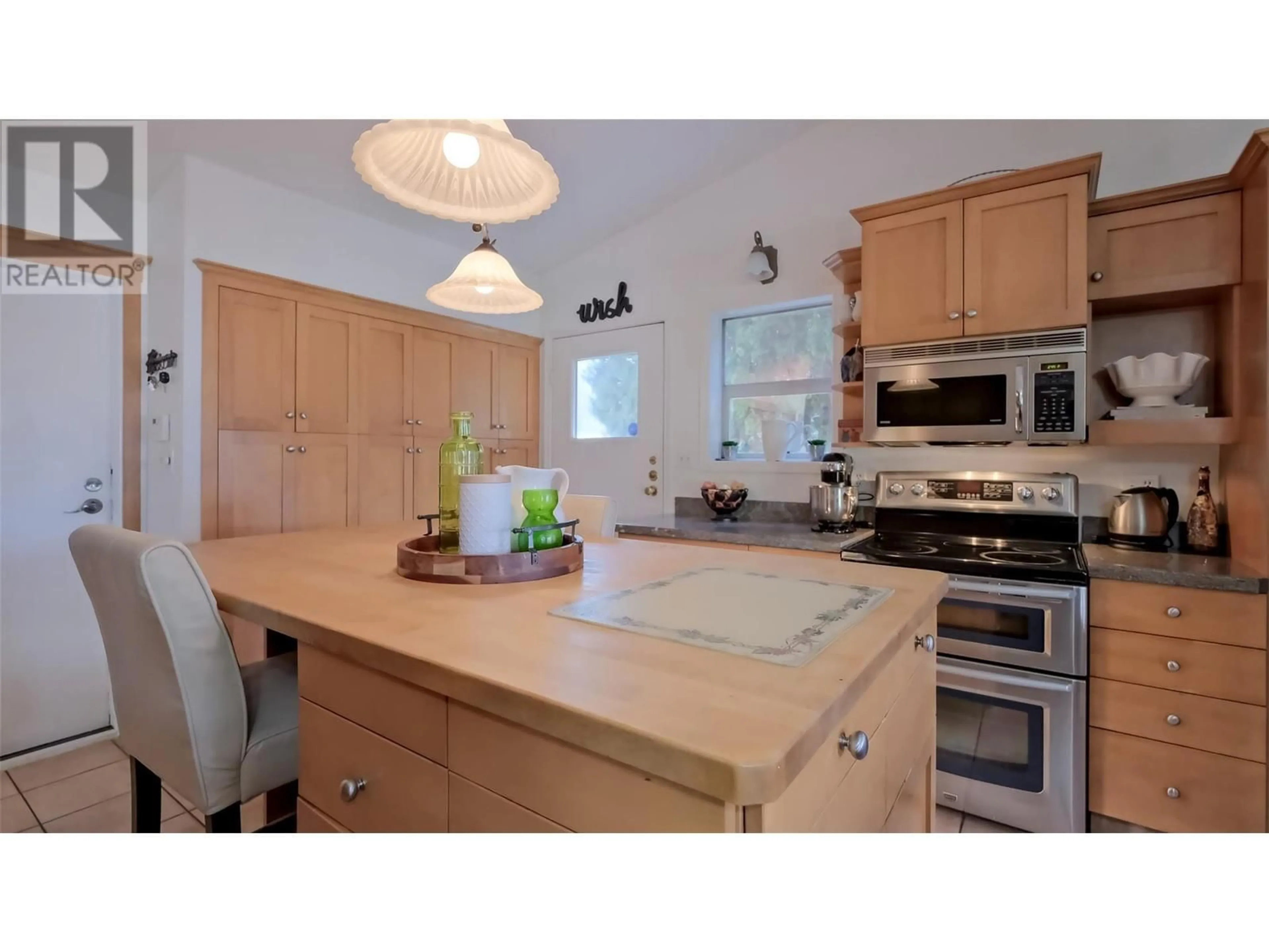 Open concept kitchen, wood/laminate floor for 921 WESTMINSTER Avenue E, Penticton British Columbia V2A1J6