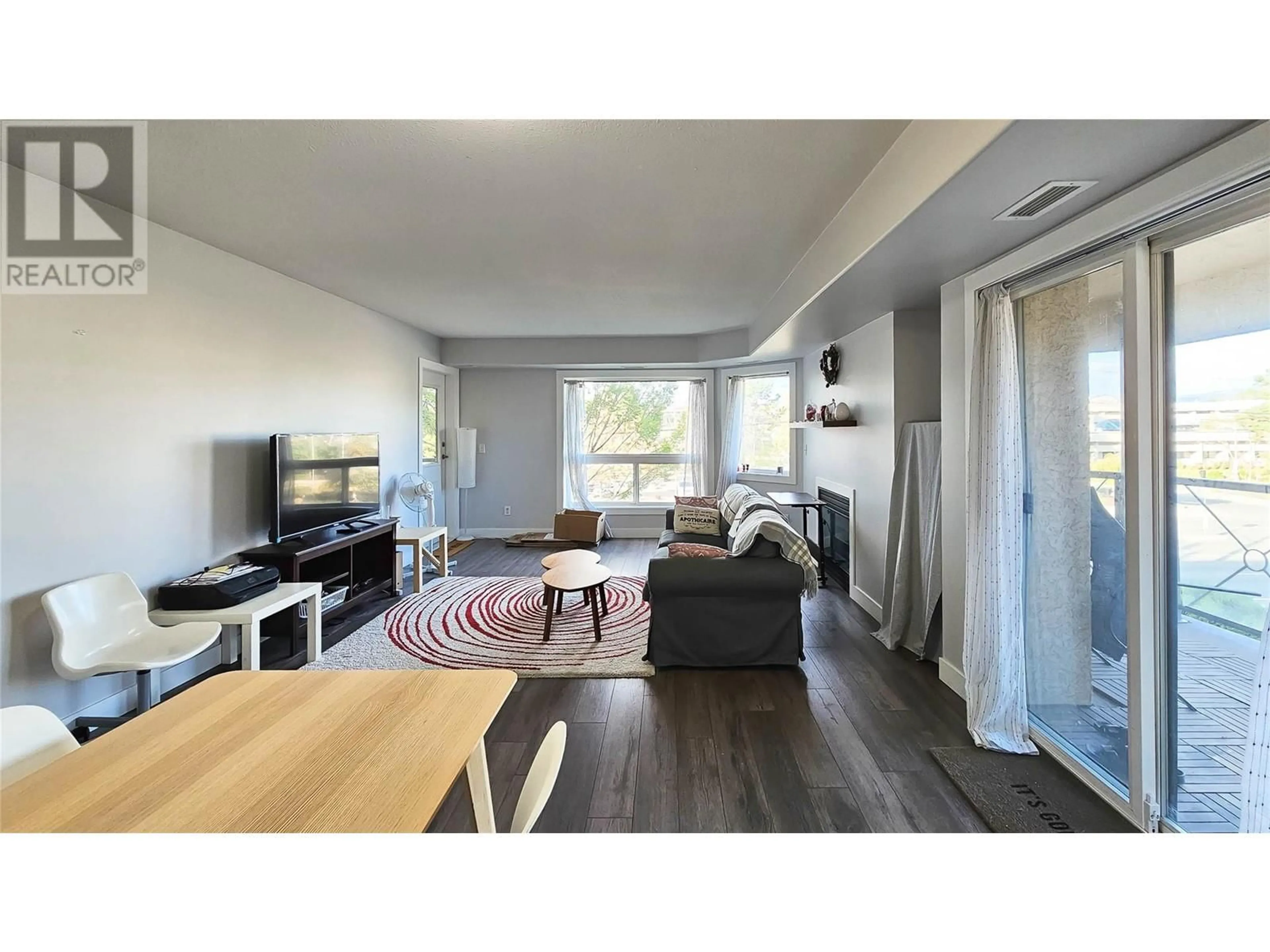 Living room with furniture, wood/laminate floor for 309 - 3115 DE MONTREUIL COURT, Kelowna British Columbia V1W3W1