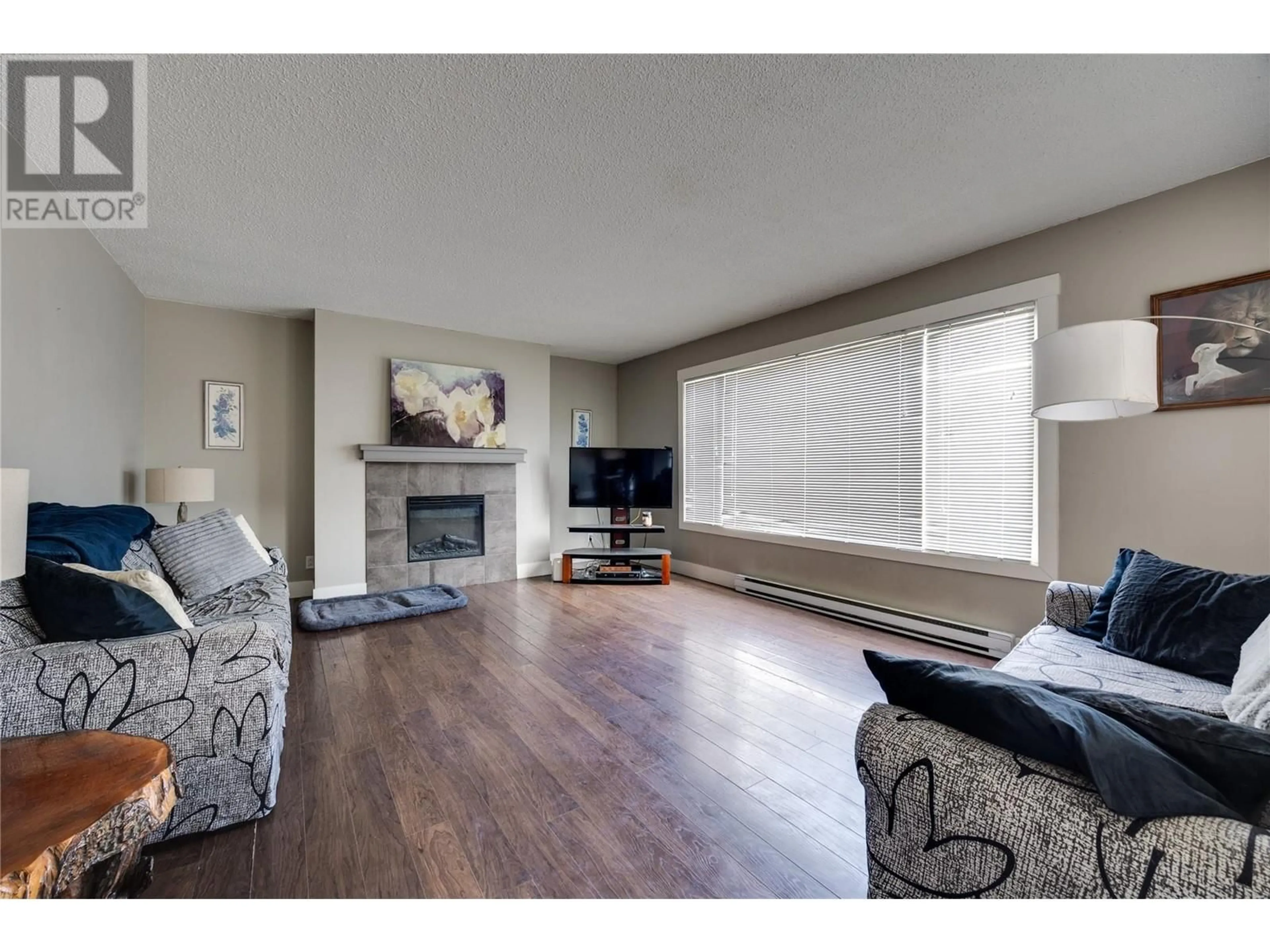 Living room with furniture, wood/laminate floor for 2126 Verde Vista Road, Kelowna British Columbia V1P1G5