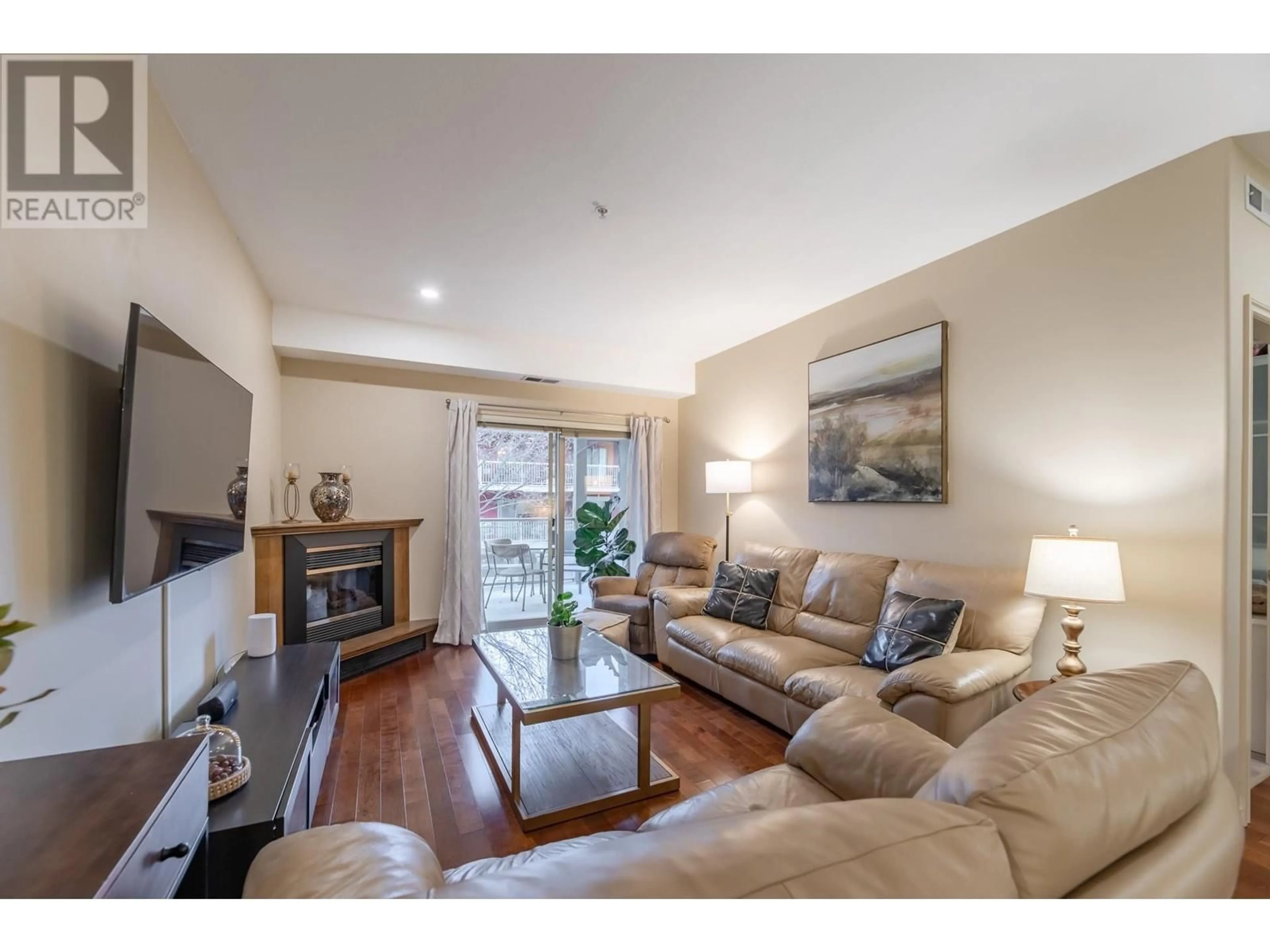 Living room with furniture, wood/laminate floor for 1007 Harvey Avenue Unit# 206, Kelowna British Columbia V1Y6E4