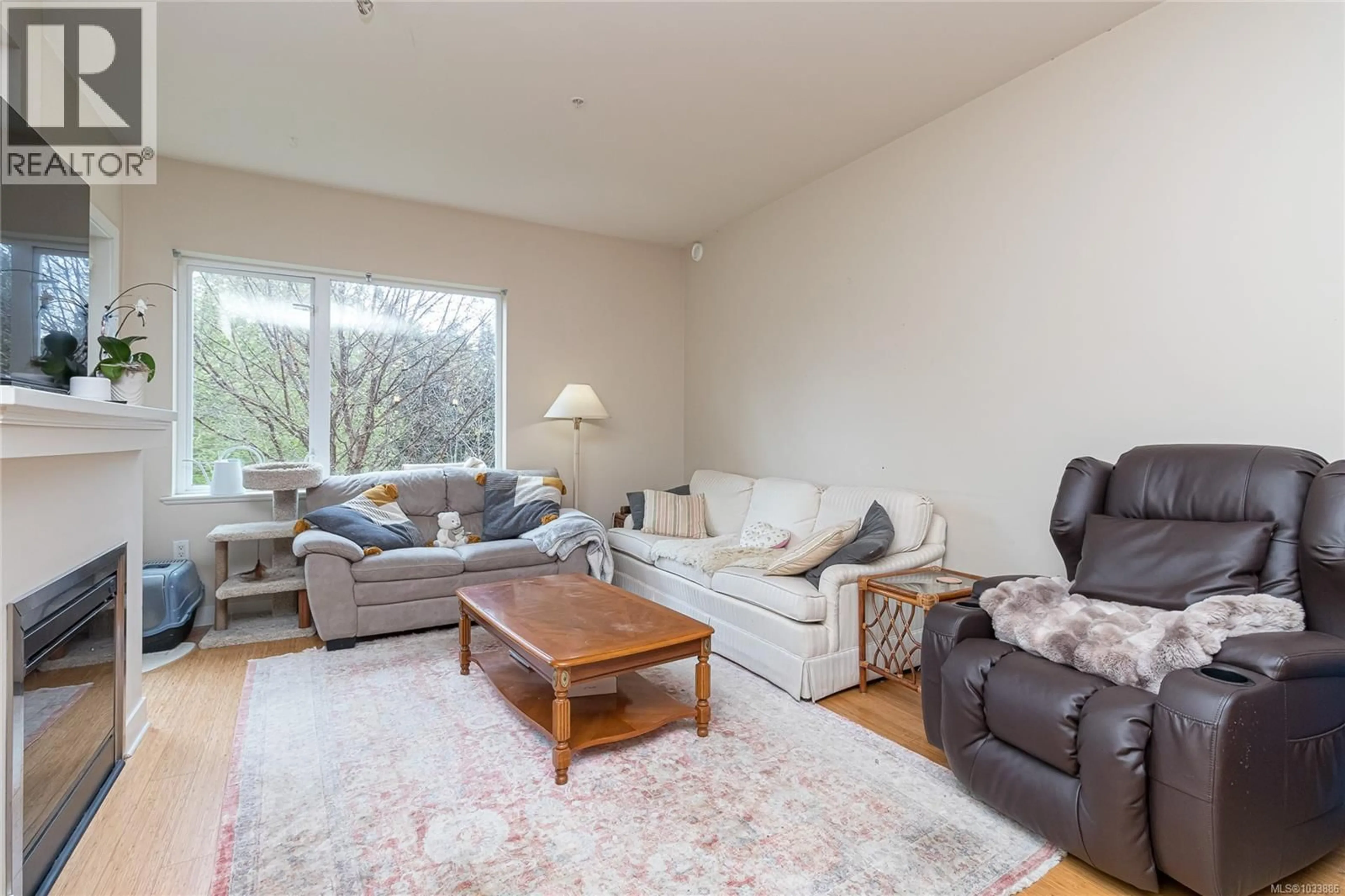 Living room with furniture, wood/laminate floor for 202 - 4394 WEST SAANICH ROAD, Saanich British Columbia V8Z0B5