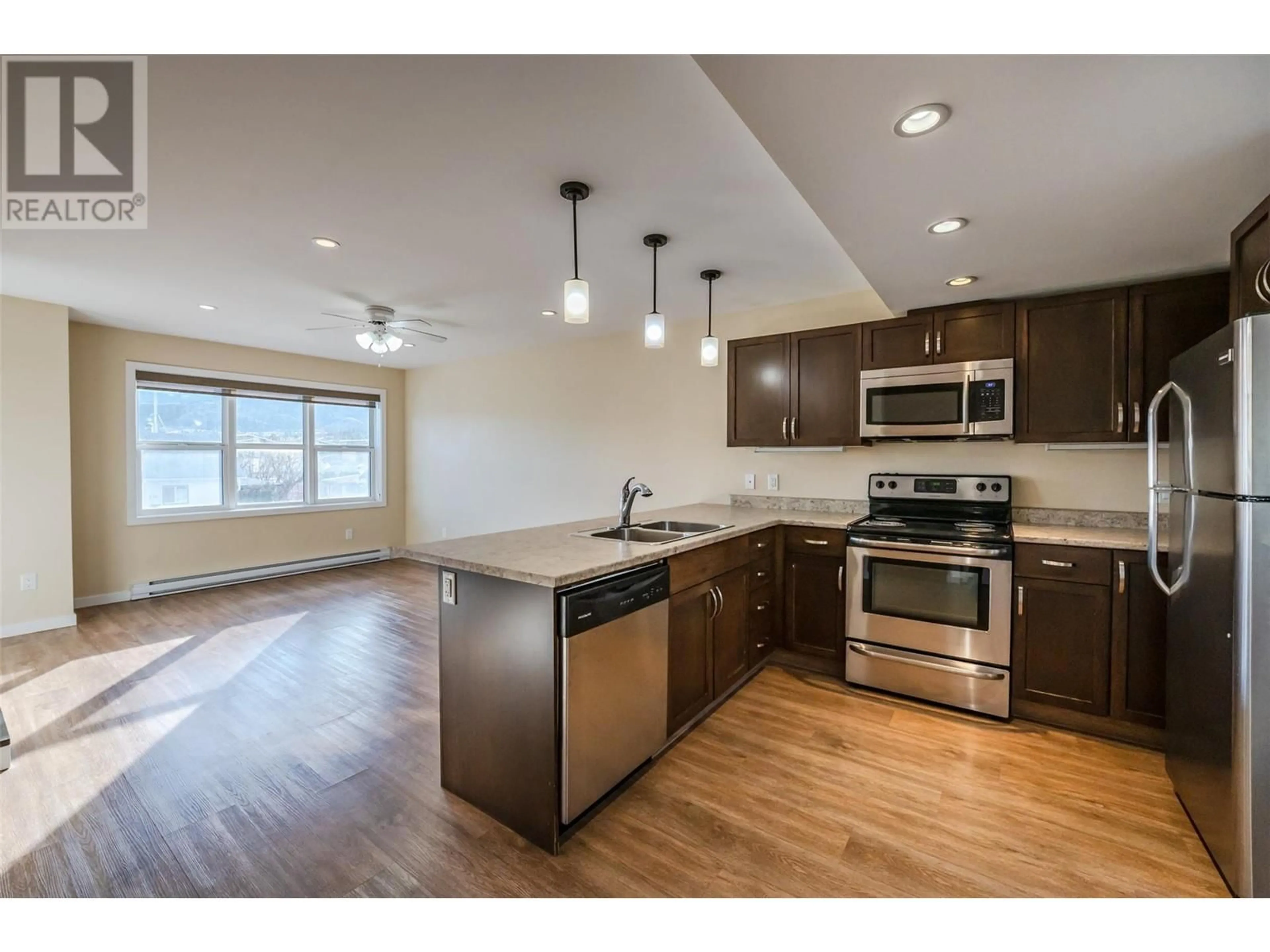 Open concept kitchen, wood/laminate floor for 707 Revelstoke Avenue Unit# 105, Penticton British Columbia V2A2J1