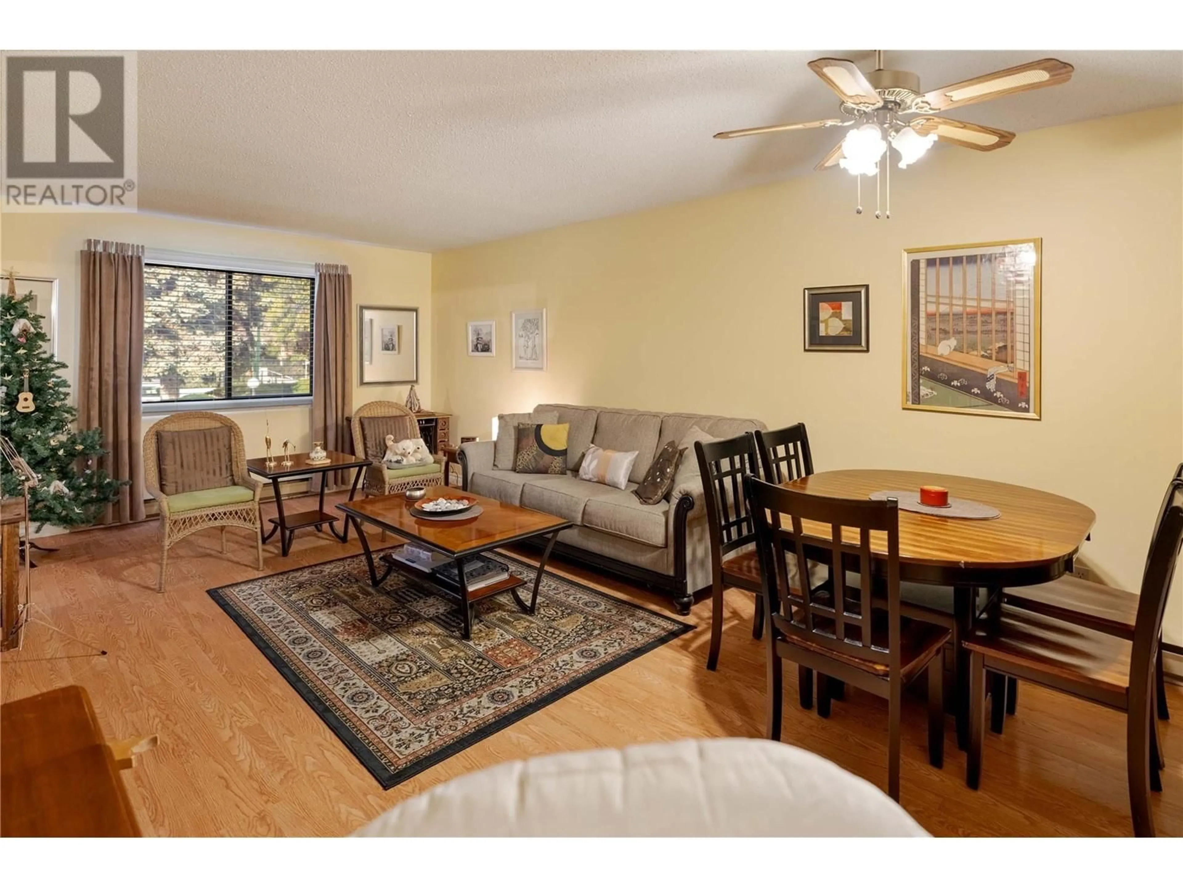 Living room with furniture, wood/laminate floor for 111 - 1035 BERNARD AVENUE, Kelowna British Columbia V1Y6P7