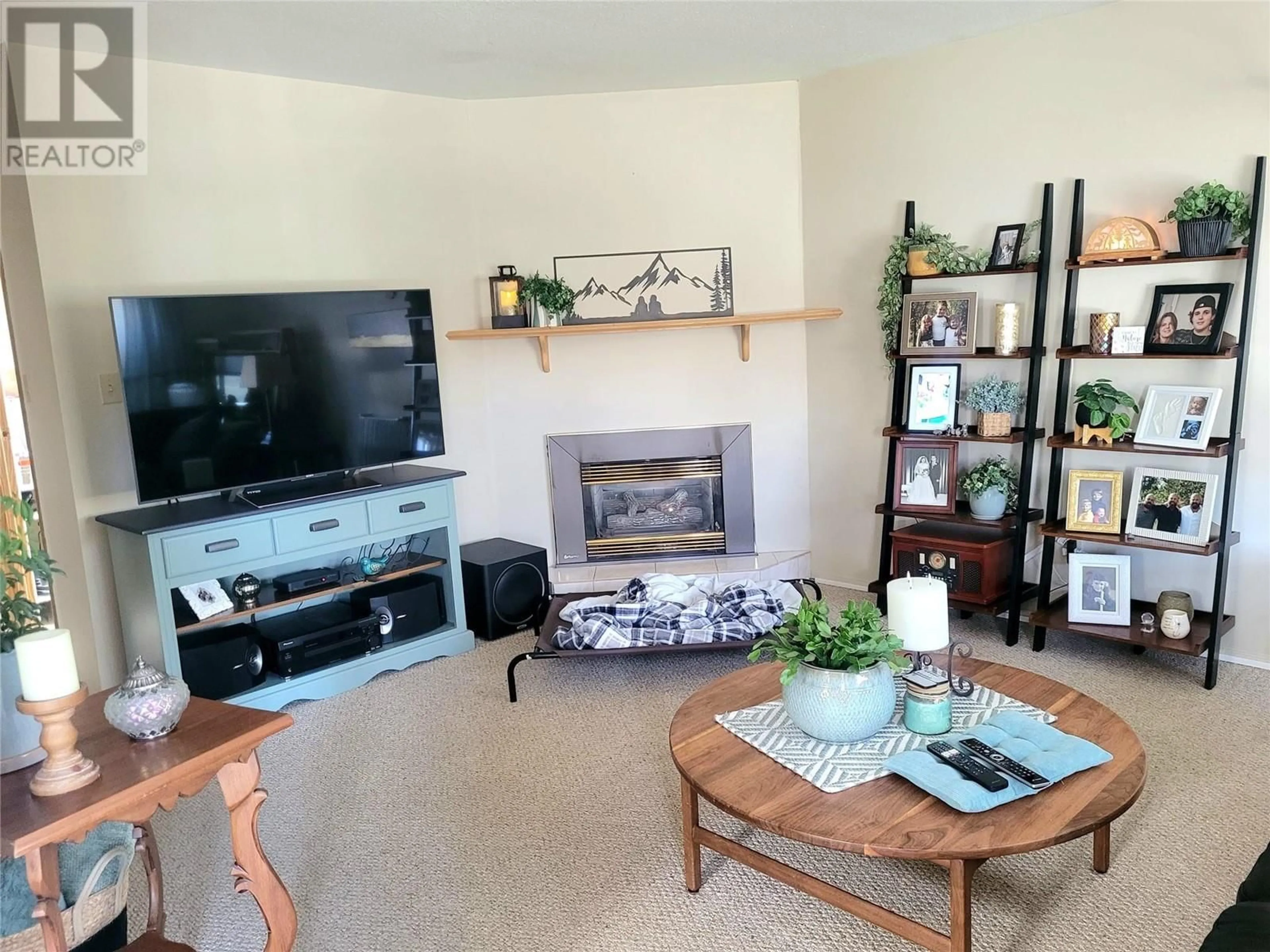 Living room with furniture, wood/laminate floor for 6834 89TH STREET, Osoyoos British Columbia V0H1V1