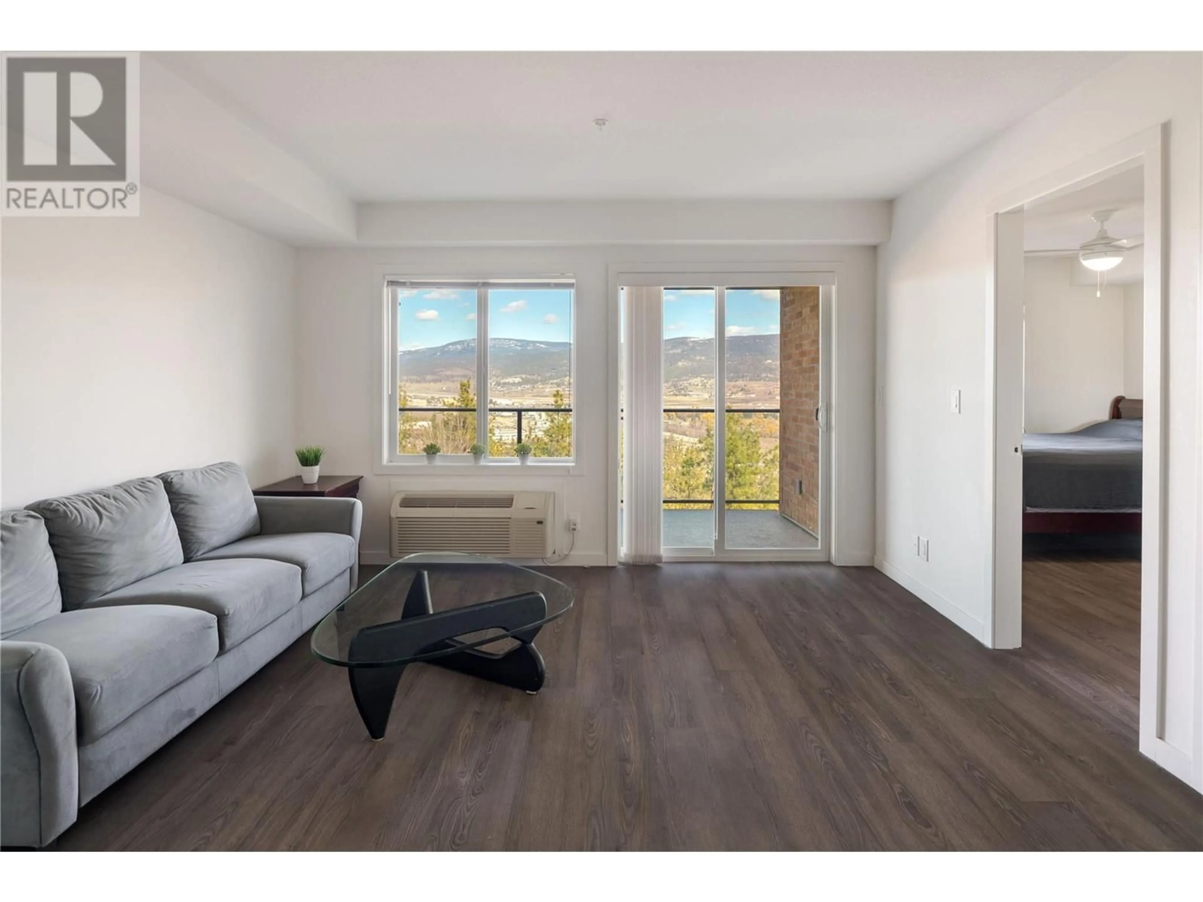 Living room with furniture, wood/laminate floor for 203 - 883 ACADEMY WAY, Kelowna British Columbia V1V0A3