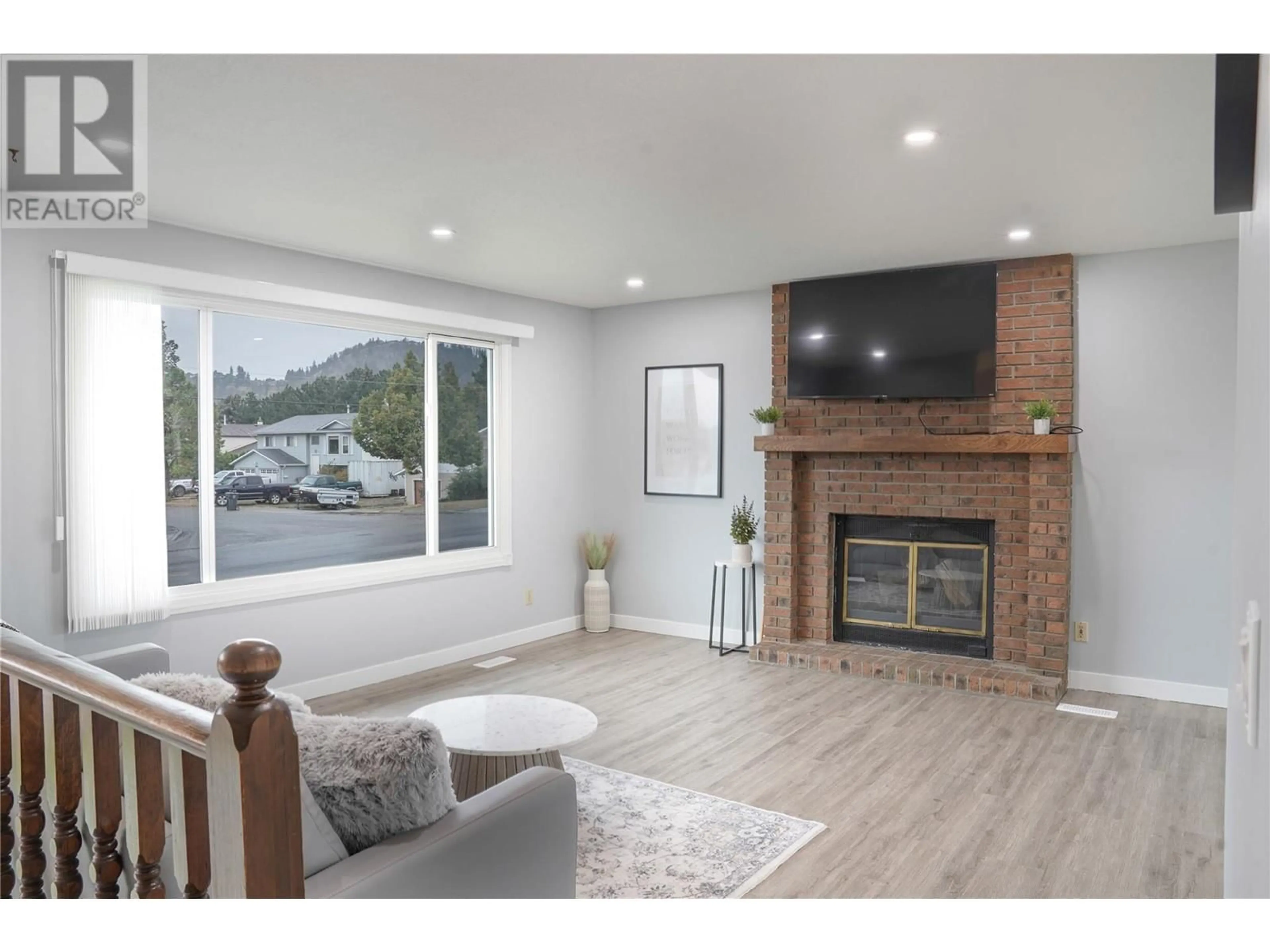 Living room with furniture, wood/laminate floor for 305 ZIPRICK ROAD, Kelowna British Columbia V1X4H2