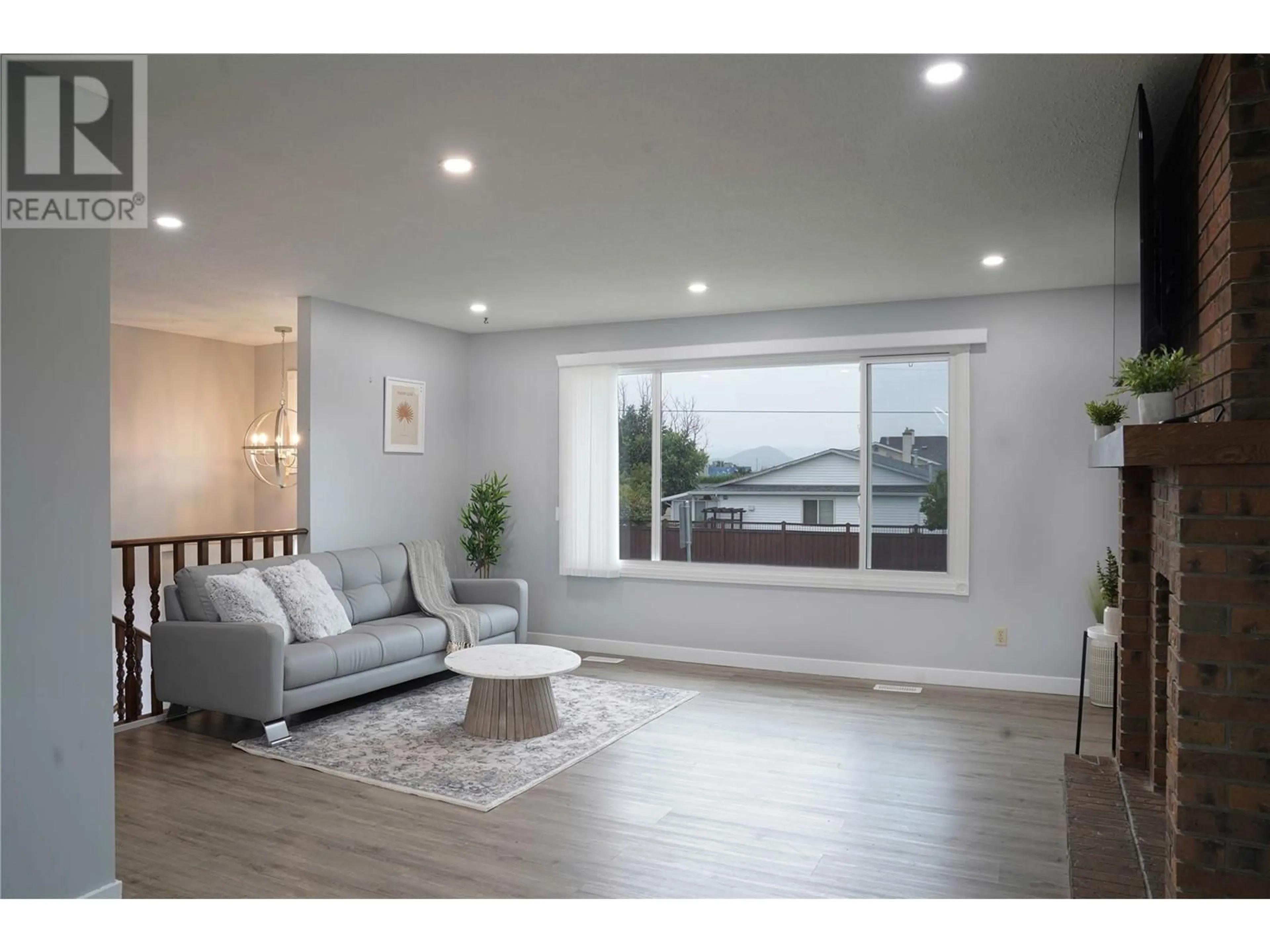 Living room with furniture, wood/laminate floor for 305 Ziprick Road, Kelowna British Columbia V1X4H2