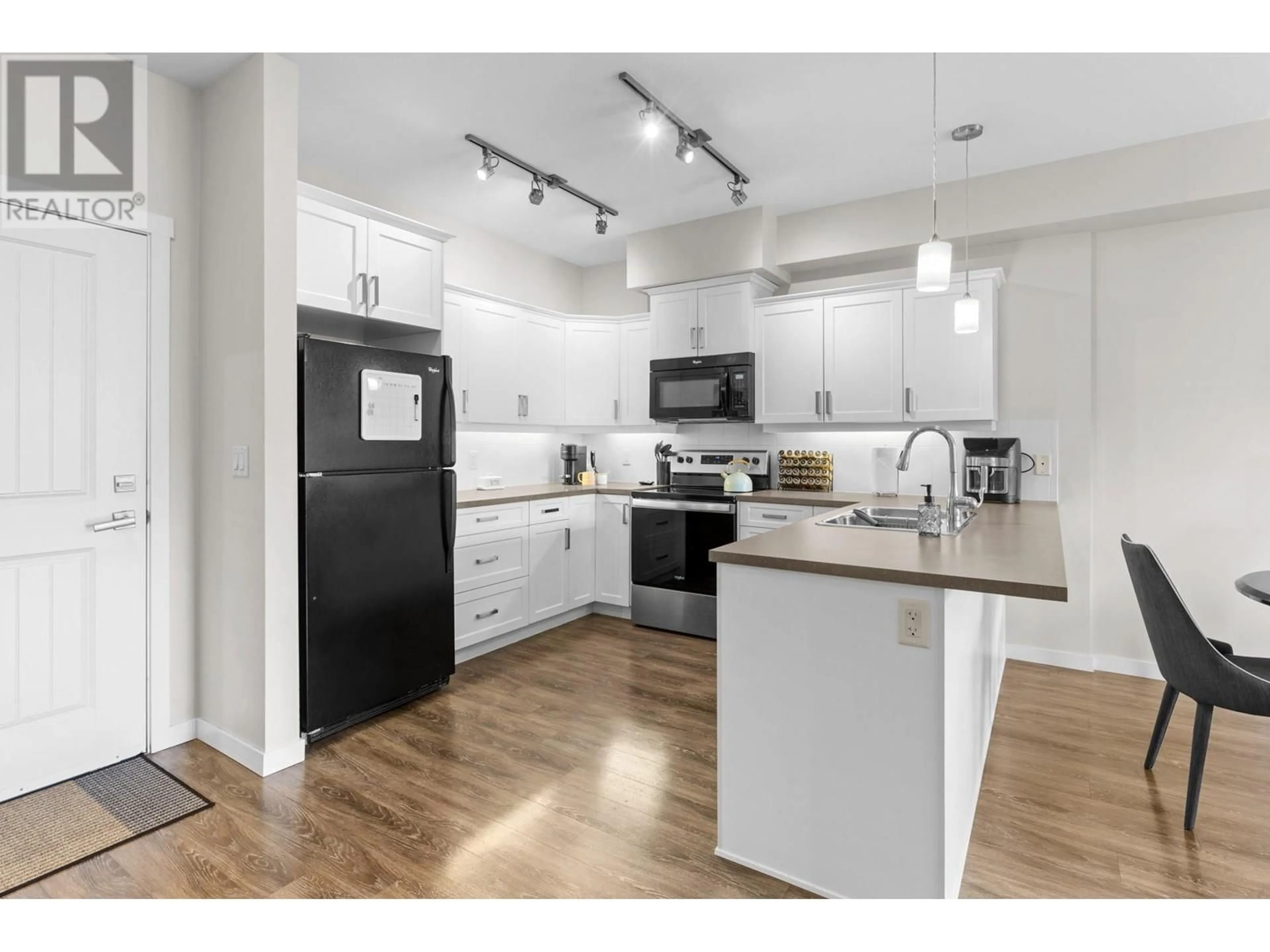 Open concept kitchen, wood/laminate floor for 3733 Casorso Road Unit# 315, Kelowna British Columbia V1W5E3