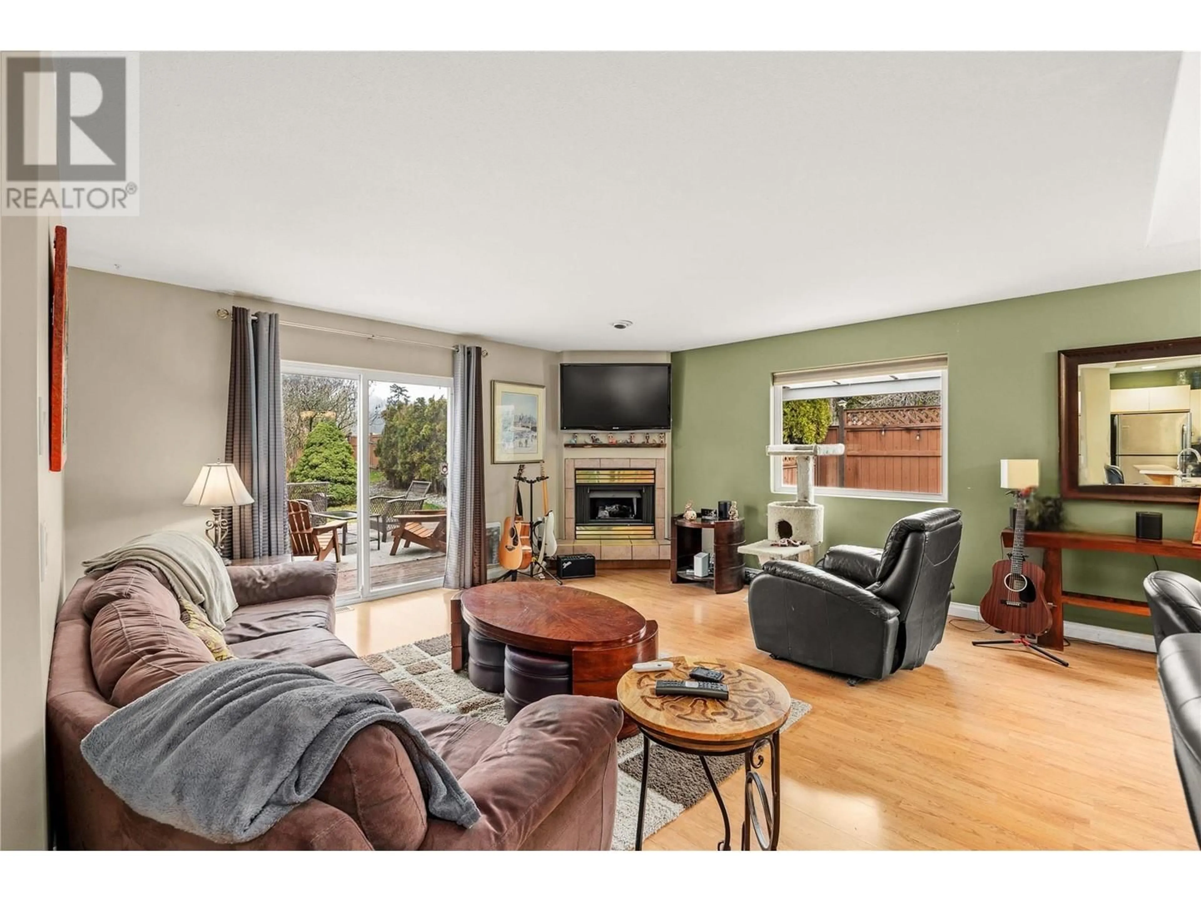 Living room with furniture, wood/laminate floor for 100 VERNA COURT, Kelowna British Columbia V4T2G3