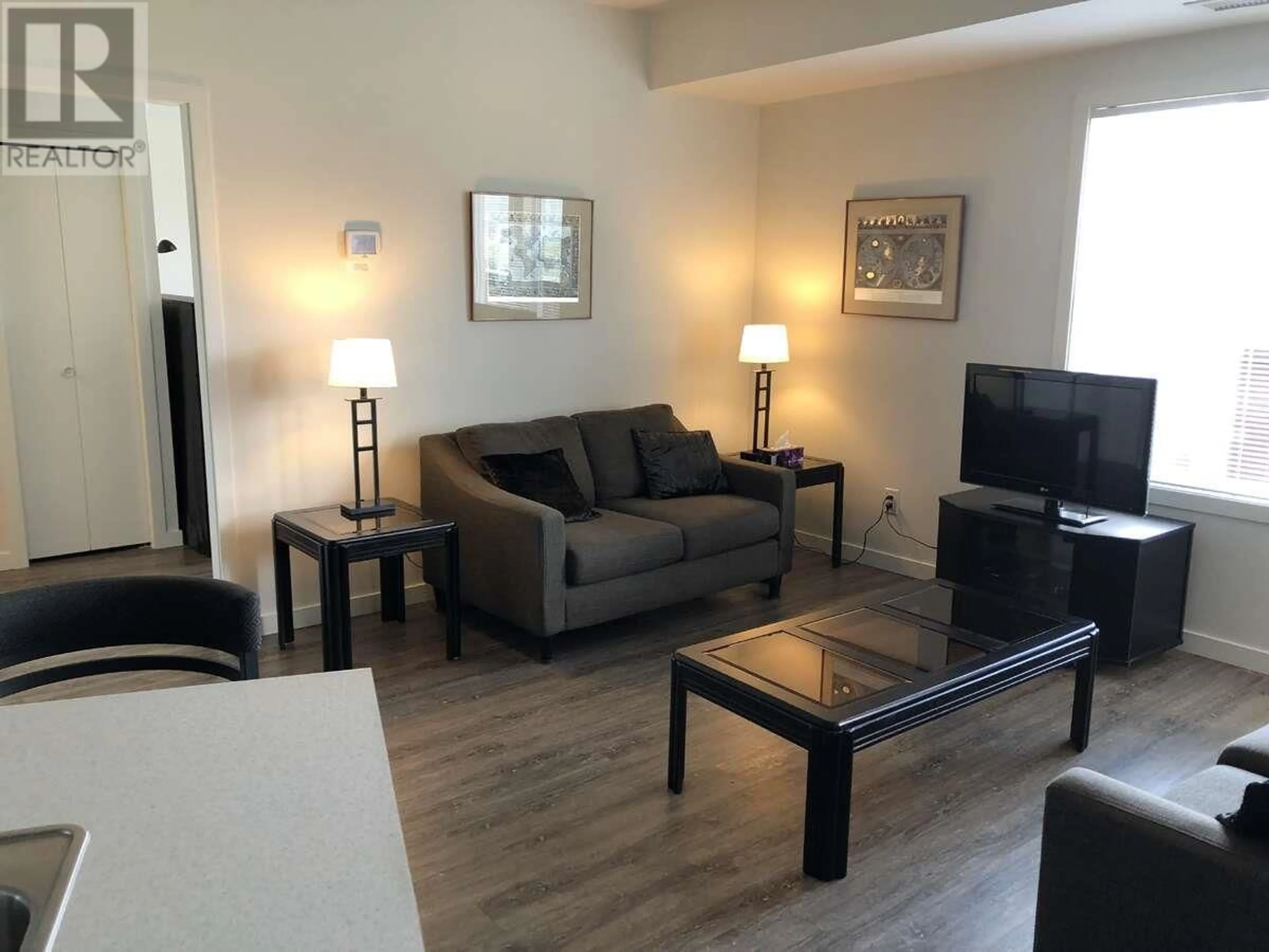 Living room with furniture, wood/laminate floor for 207 - 935 ACADEMY WAY, Kelowna British Columbia V1V3C9