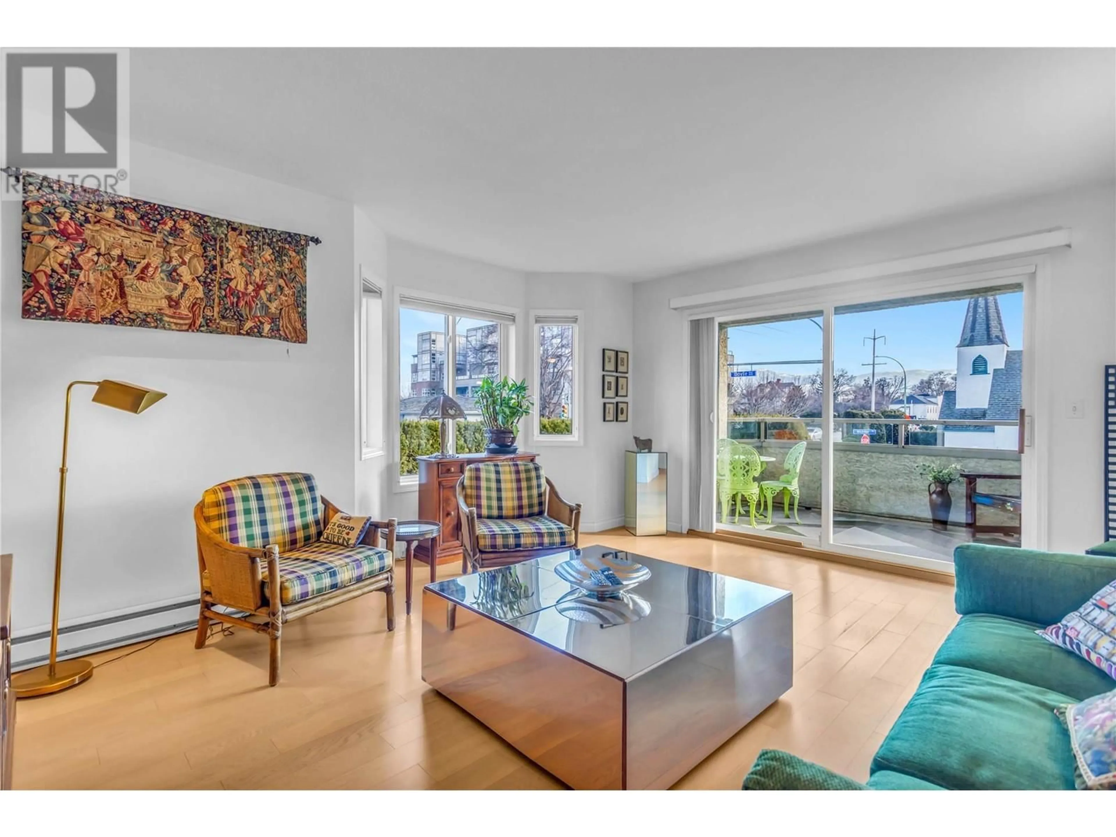 Living room with furniture, wood/laminate floor for 101 - 680 DOYLE AVENUE, Kelowna British Columbia V1Y9S2