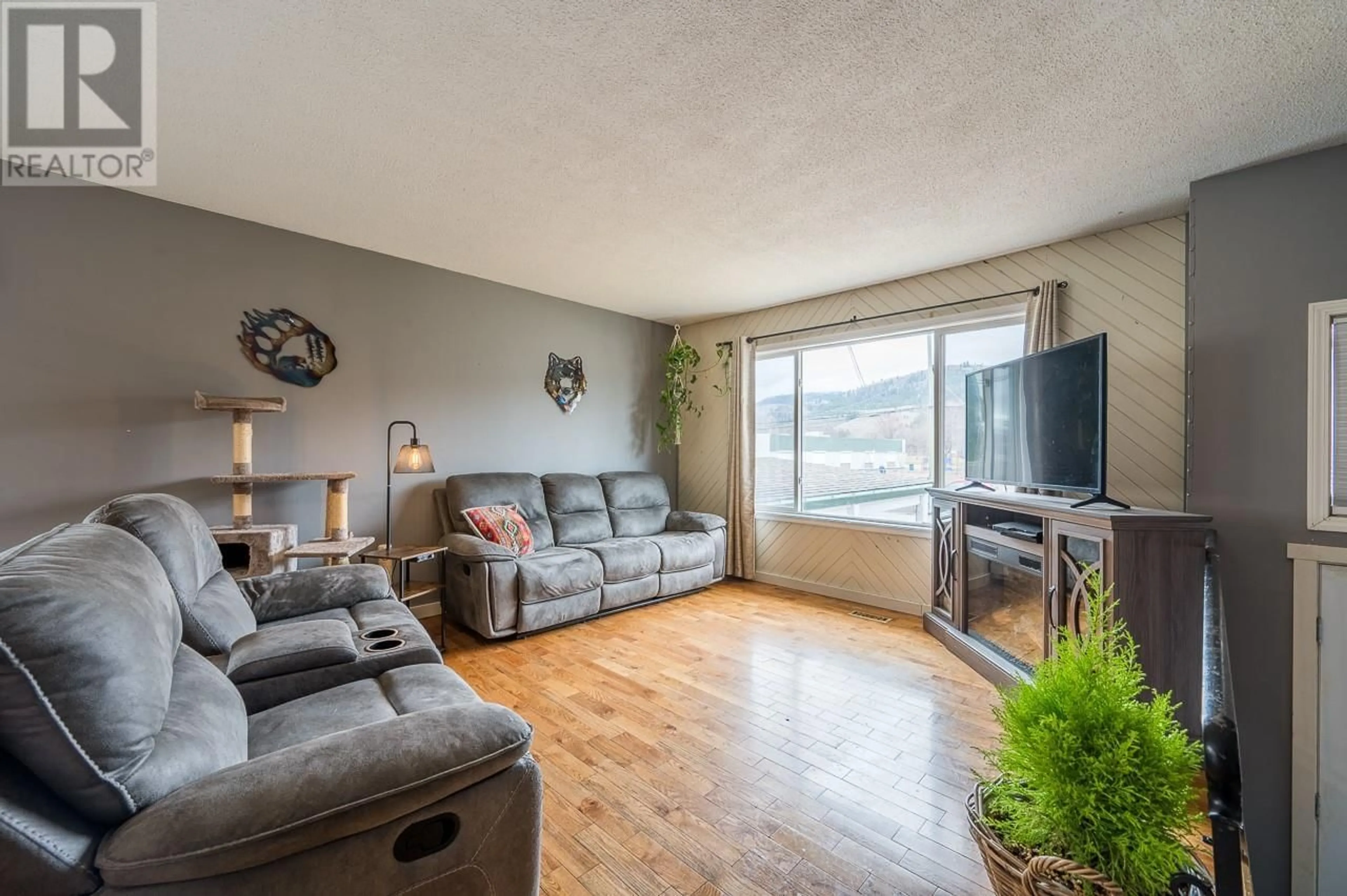 Living room with furniture, wood/laminate floor for 4588 CAMMERAY DRIVE, Kamloops British Columbia V2H1L4