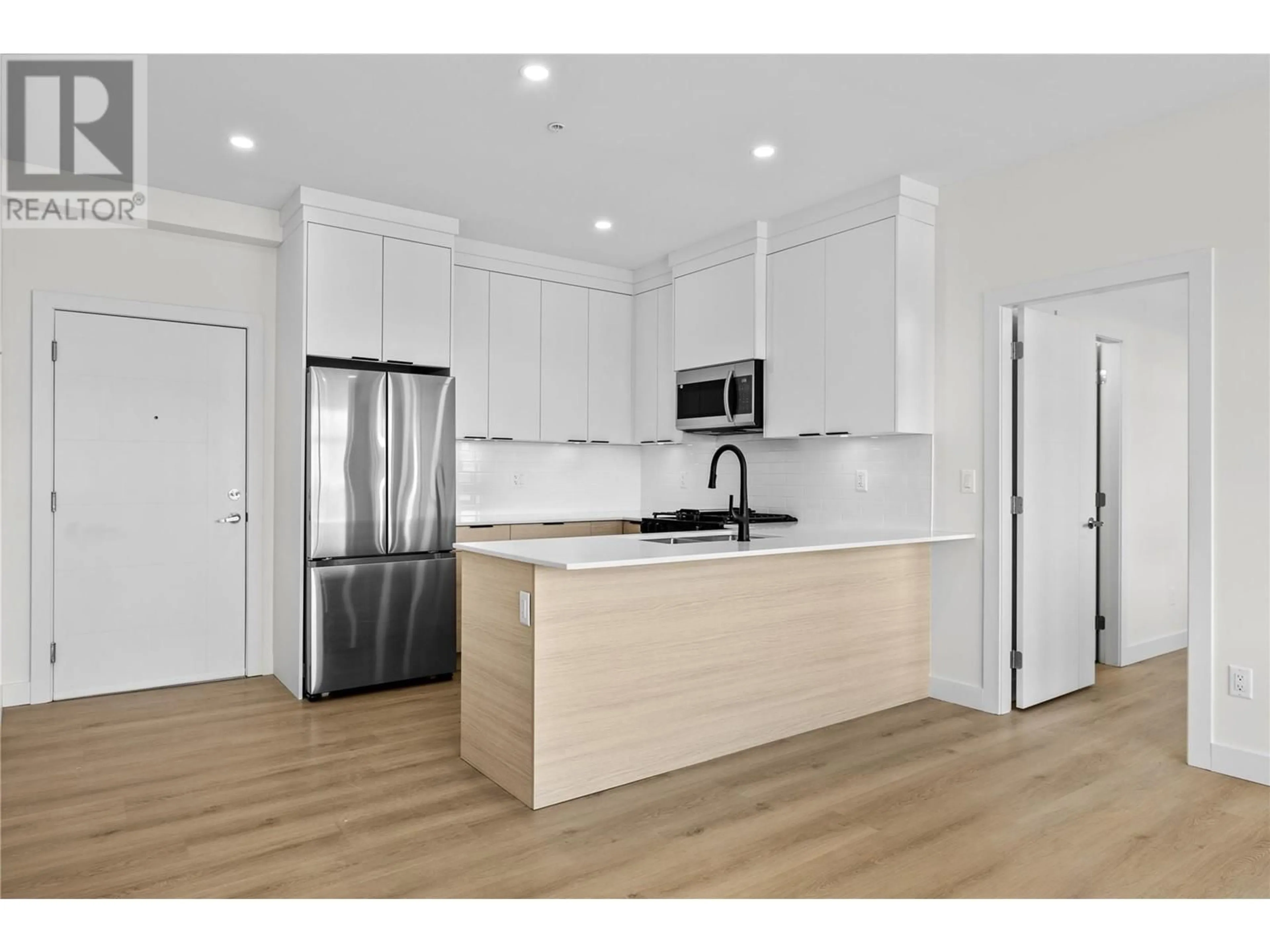 Open concept kitchen, wood/laminate floor for 203 - 5300 MAIN STREET, Kelowna British Columbia V1W0C1