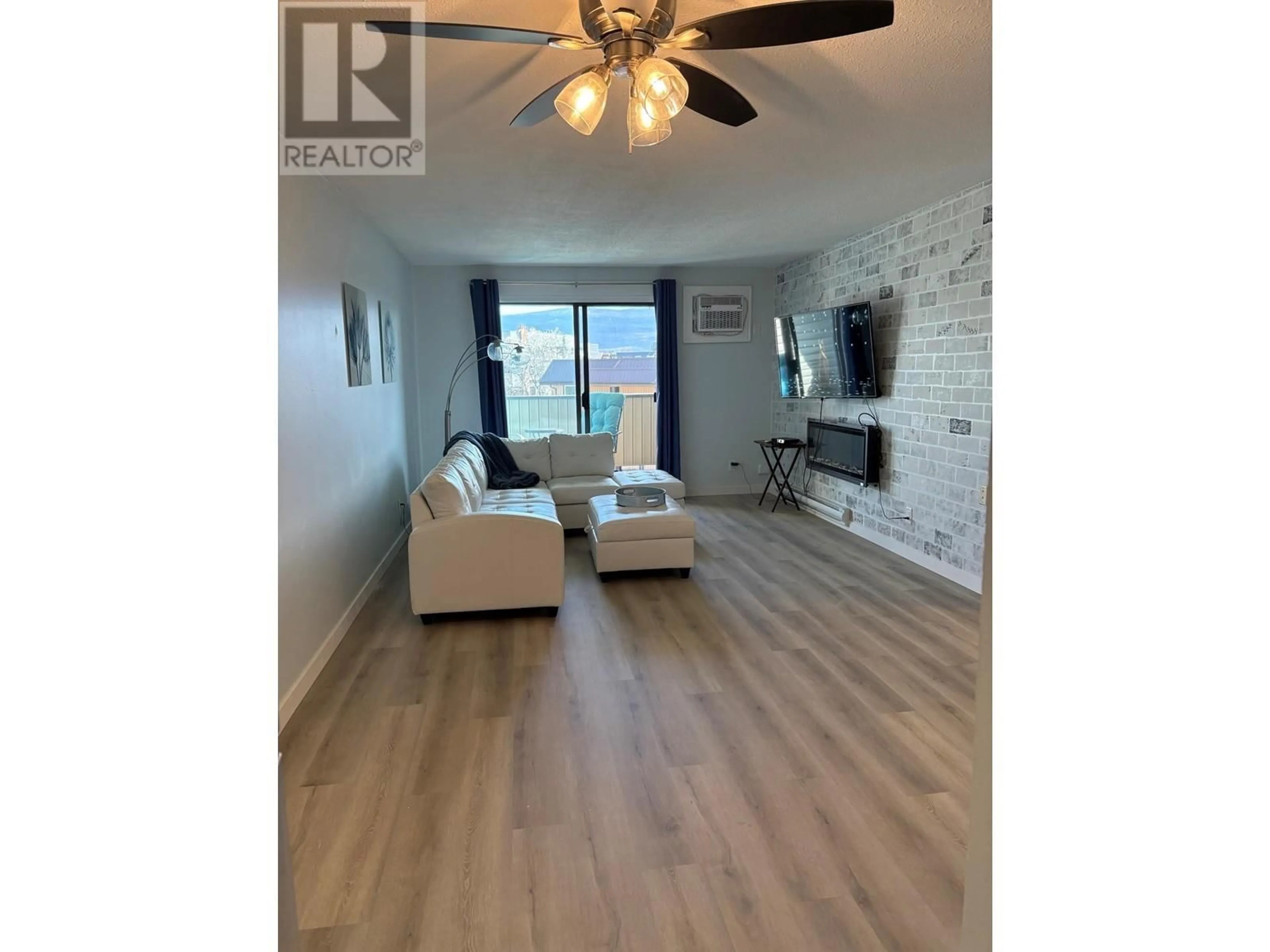 Living room with furniture, wood/laminate floor for 211 - 1640 UFTON COURT, Kelowna British Columbia V1Y8L5