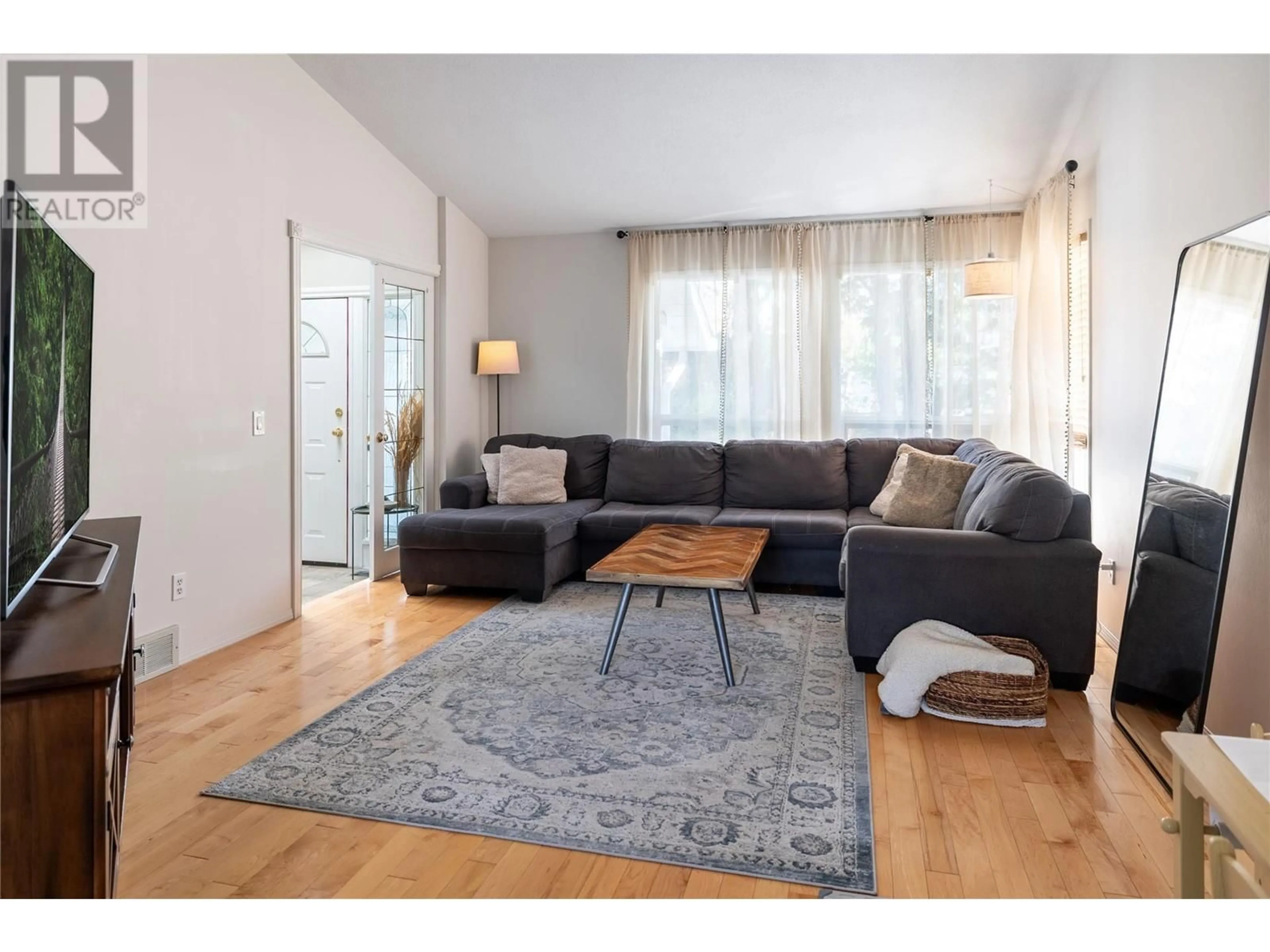 Living room with furniture, wood/laminate floor for 4452 LAKESHORE ROAD, Kelowna British Columbia V1W1W8