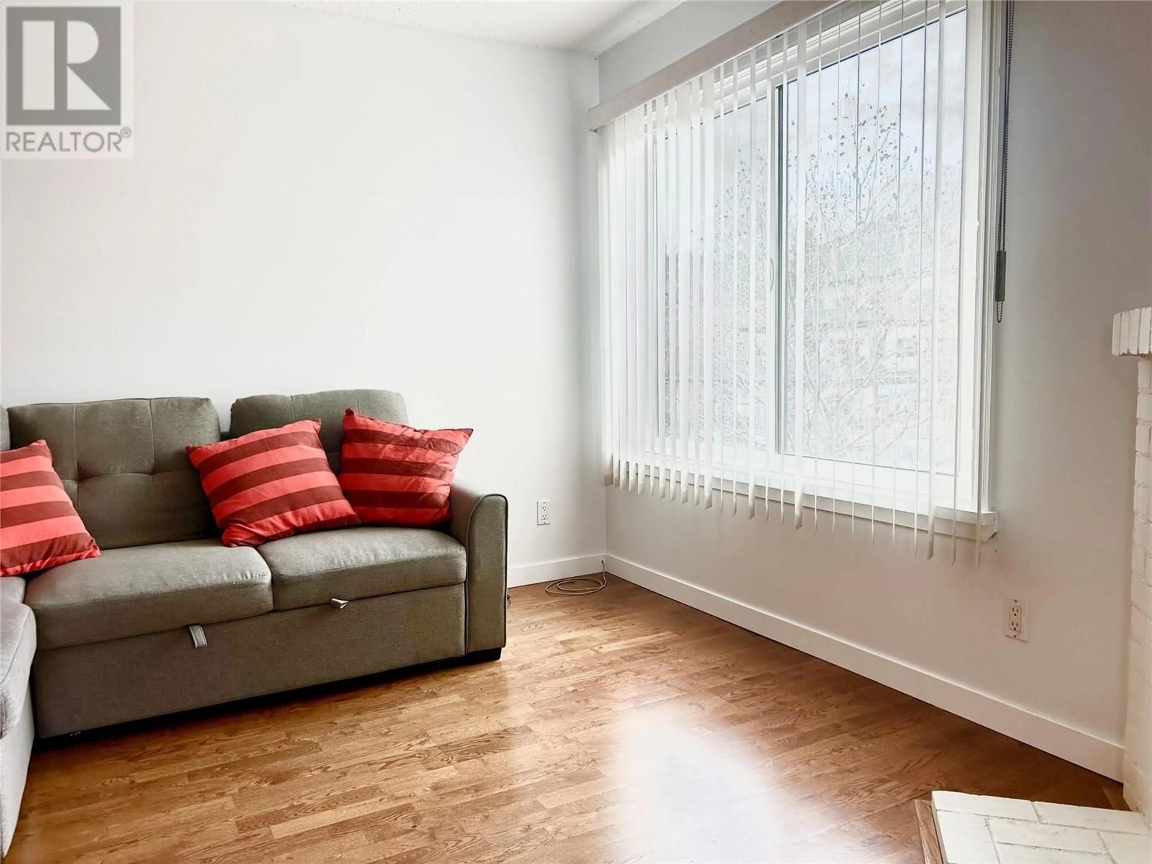 Living room with furniture, wood/laminate floor for 335 - 1665 UFTON COURT, Kelowna British Columbia V1Y8G7