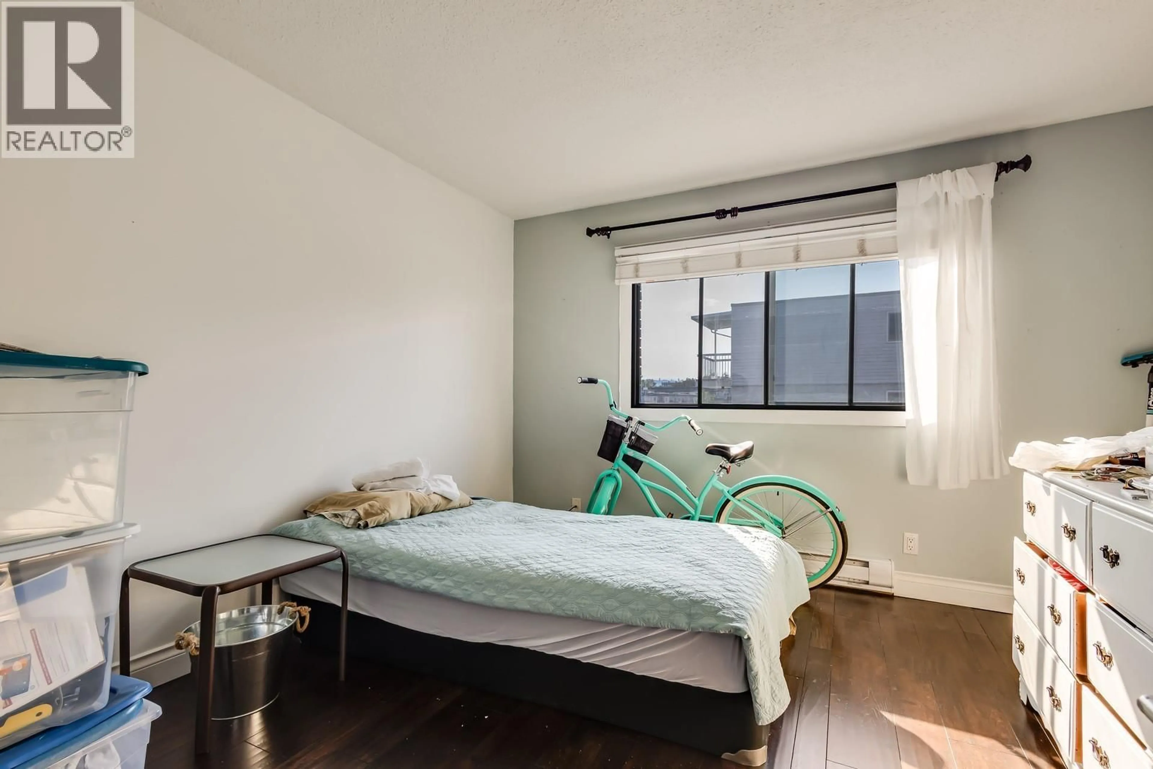 Bedroom with bed, wood/laminate floor for 204 - 1860 RICHTER STREET, Kelowna British Columbia V1Y2M9