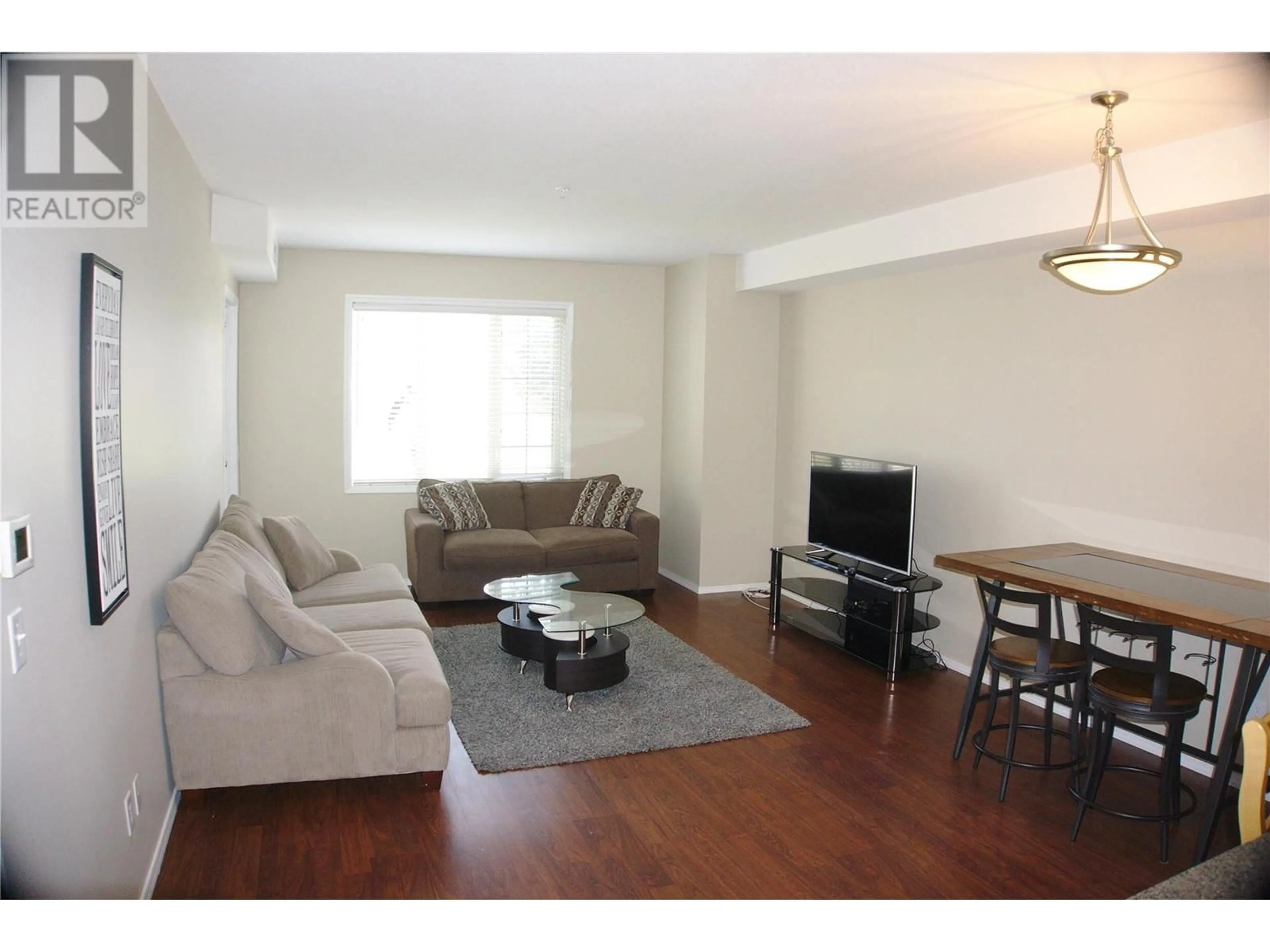 Living room with furniture, wood/laminate floor for 1316 - 1875 COUNTRY CLUB DRIVE, Kelowna British Columbia V1V2W7