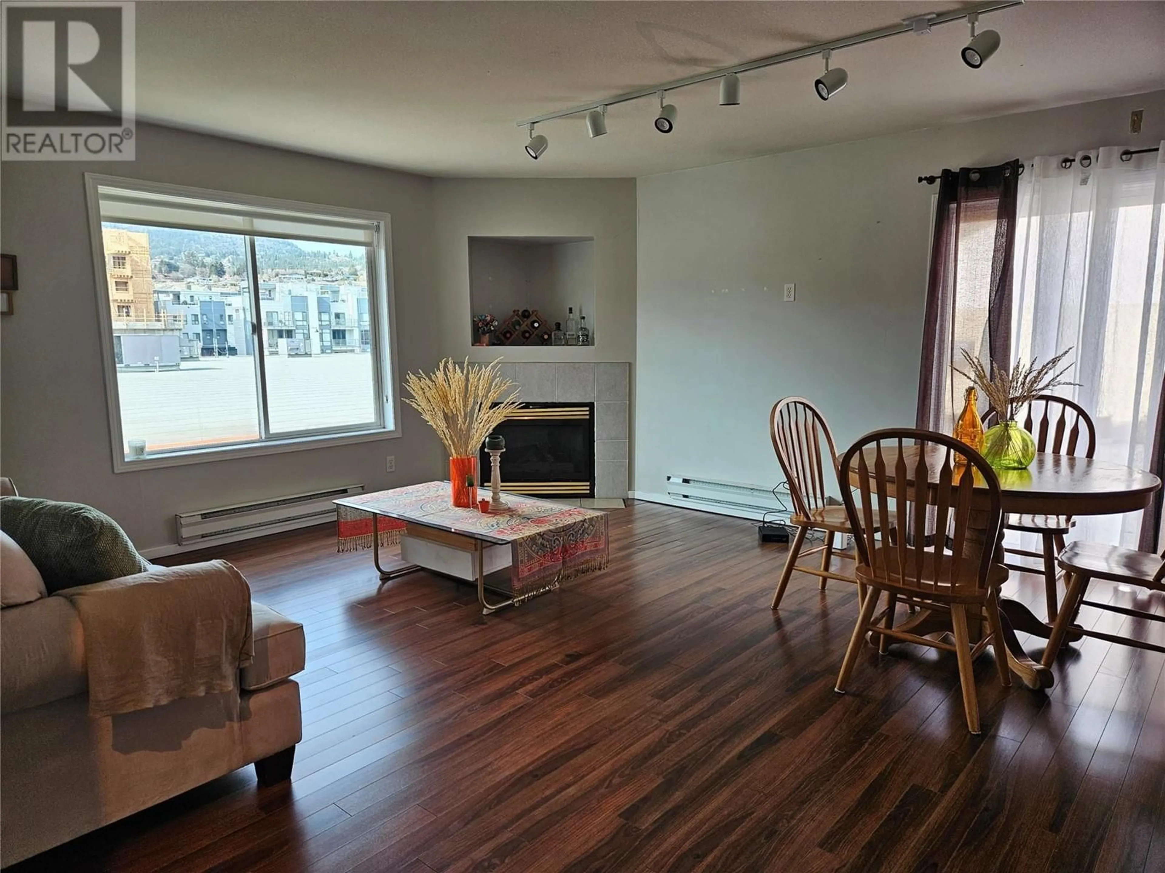 Living room with furniture, wood/laminate floor for 201 - 1027 WESTMINSTER AVENUE WEST, Penticton British Columbia V2A5C5