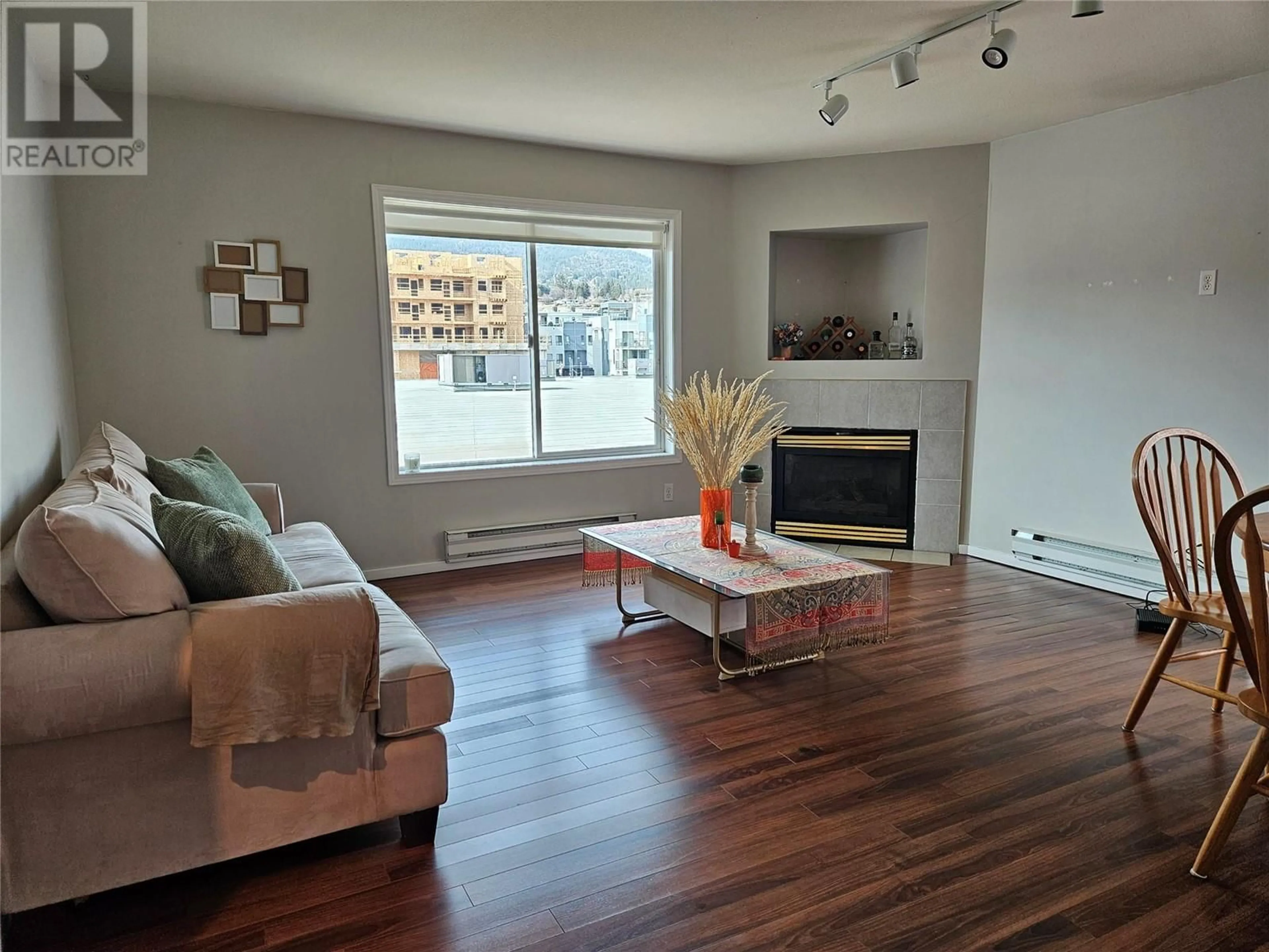 Living room with furniture, wood/laminate floor for 201 - 1027 WESTMINSTER AVENUE WEST, Penticton British Columbia V2A5C5