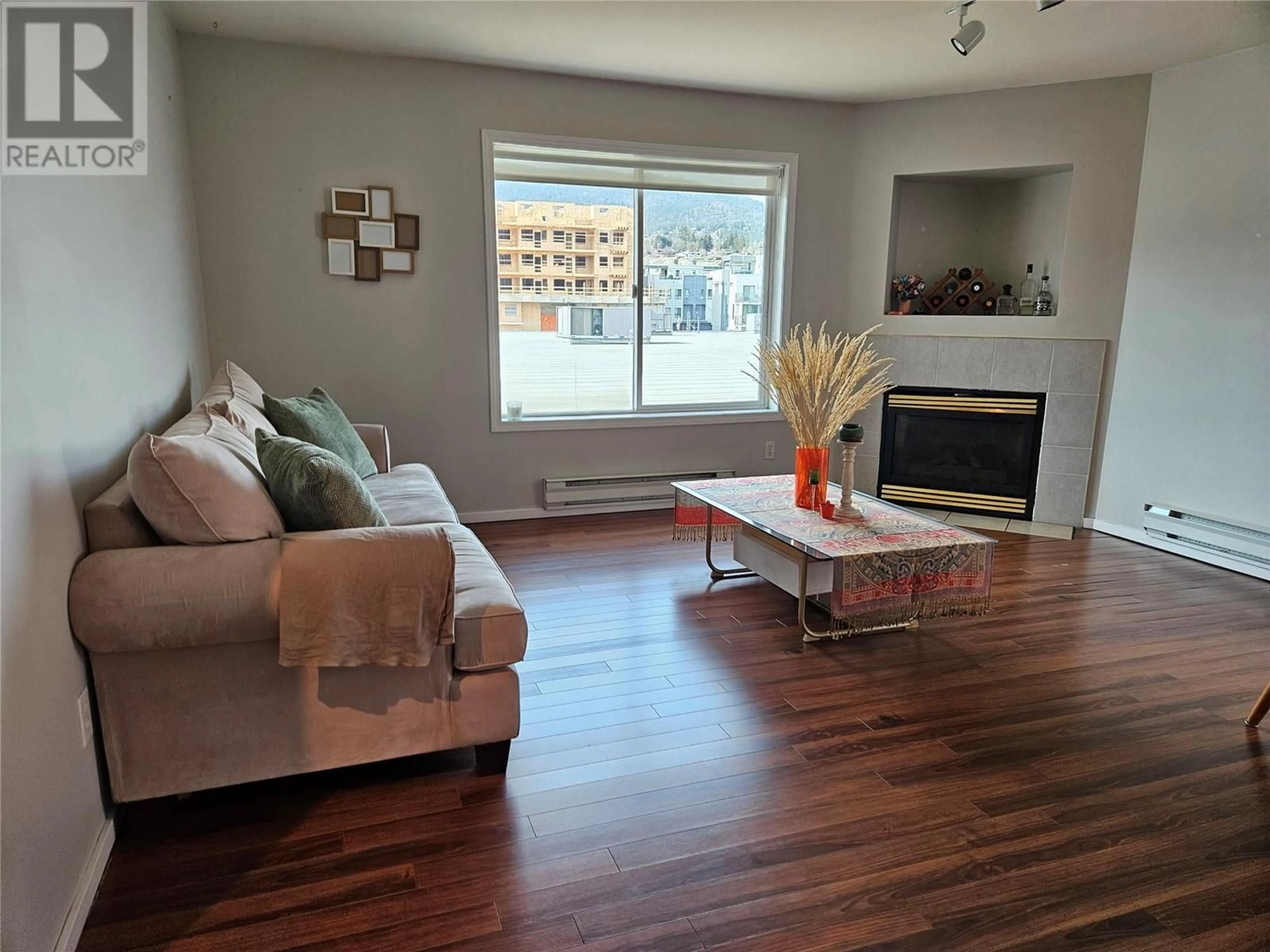Living room with furniture, wood/laminate floor for 201 - 1027 WESTMINSTER AVENUE WEST, Penticton British Columbia V2A5C5